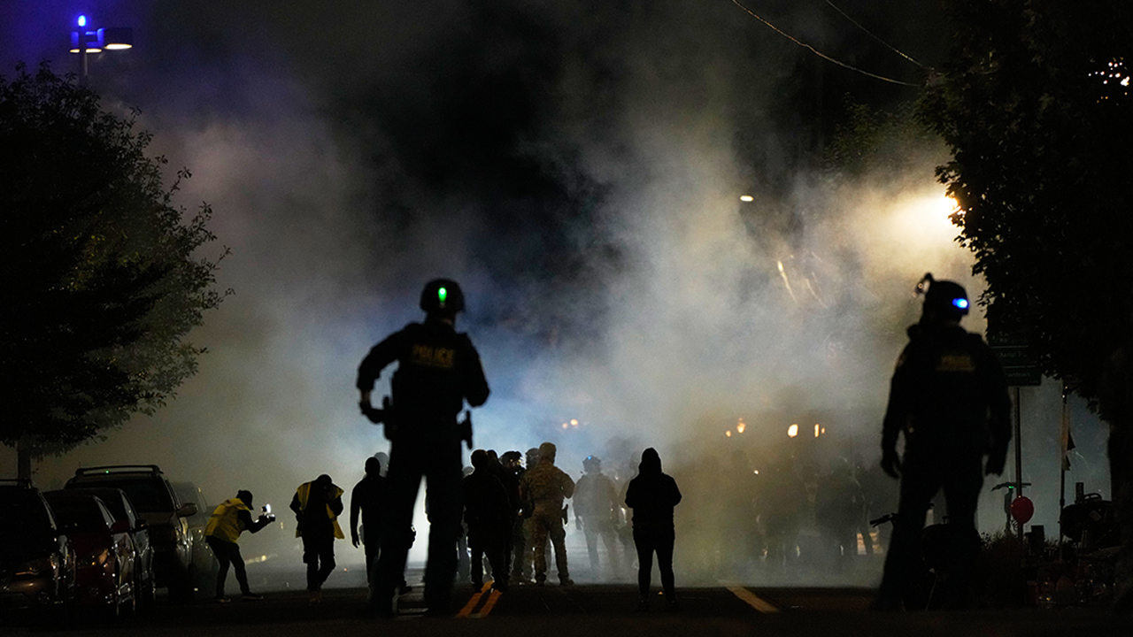 Law enforcement officers stand after deploying tear gas outside a U.S. Immigration and Customs Enforcement facility during a protest on Saturday, Oct. 4, 2025, in Portland, Ore.