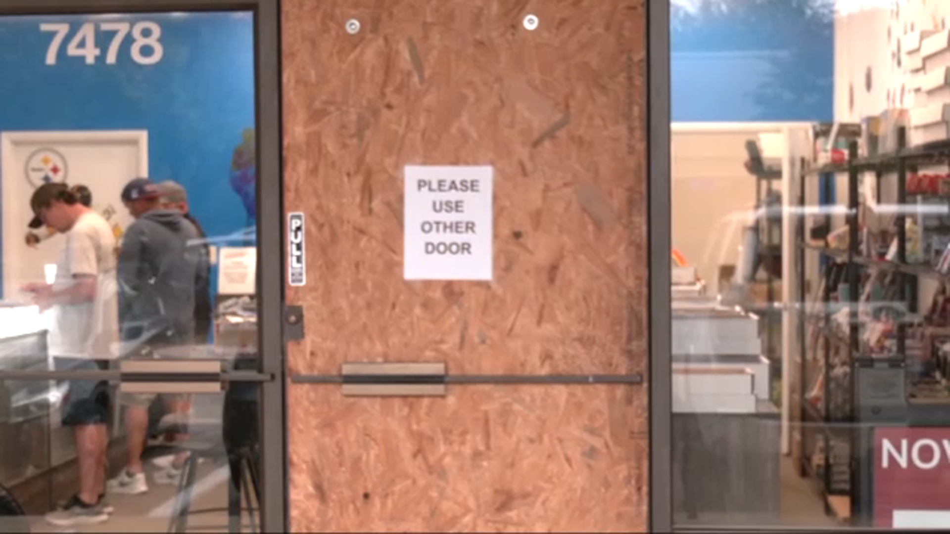 One door is boarded up at Crunch Time Sports Cards in Raleigh after a thief smashed the glass.