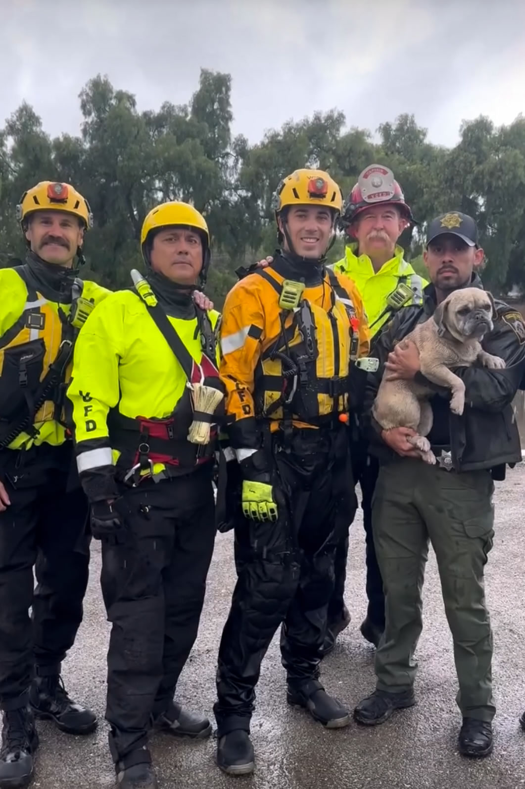 This photo from Ventura County Fire Department, members of VCFD and Oxnard Fire Department pose with a dog rescued from a flood channel in Ventura Co., Calif., on Oct. 14, 2025.