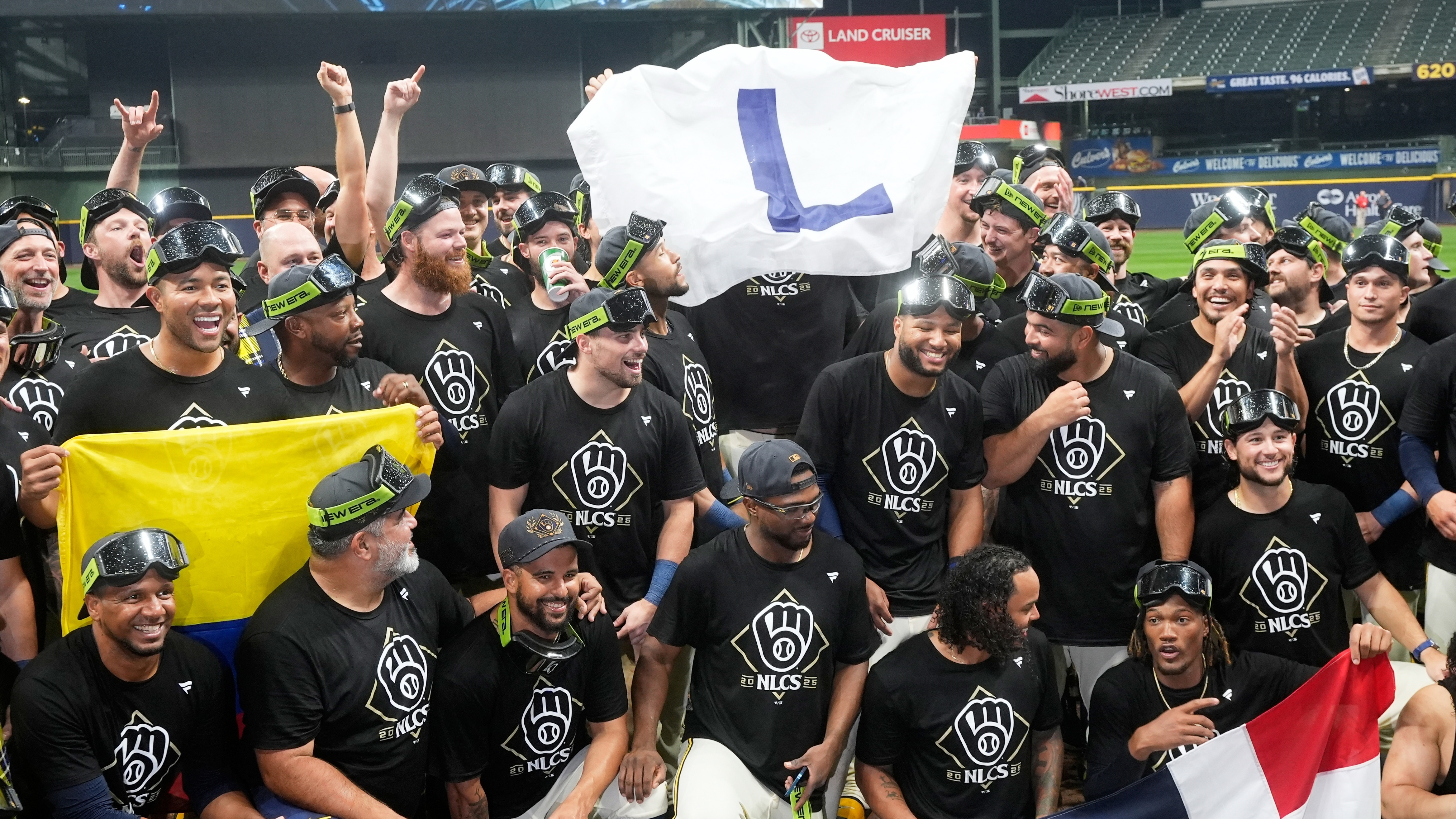 Milwaukee Brewers hold a flag as they pose for a picture after Game 5 of baseball's National League Division Series against the Chicago Cubs Saturday, Oct. 11, 2025, in Milwaukee.