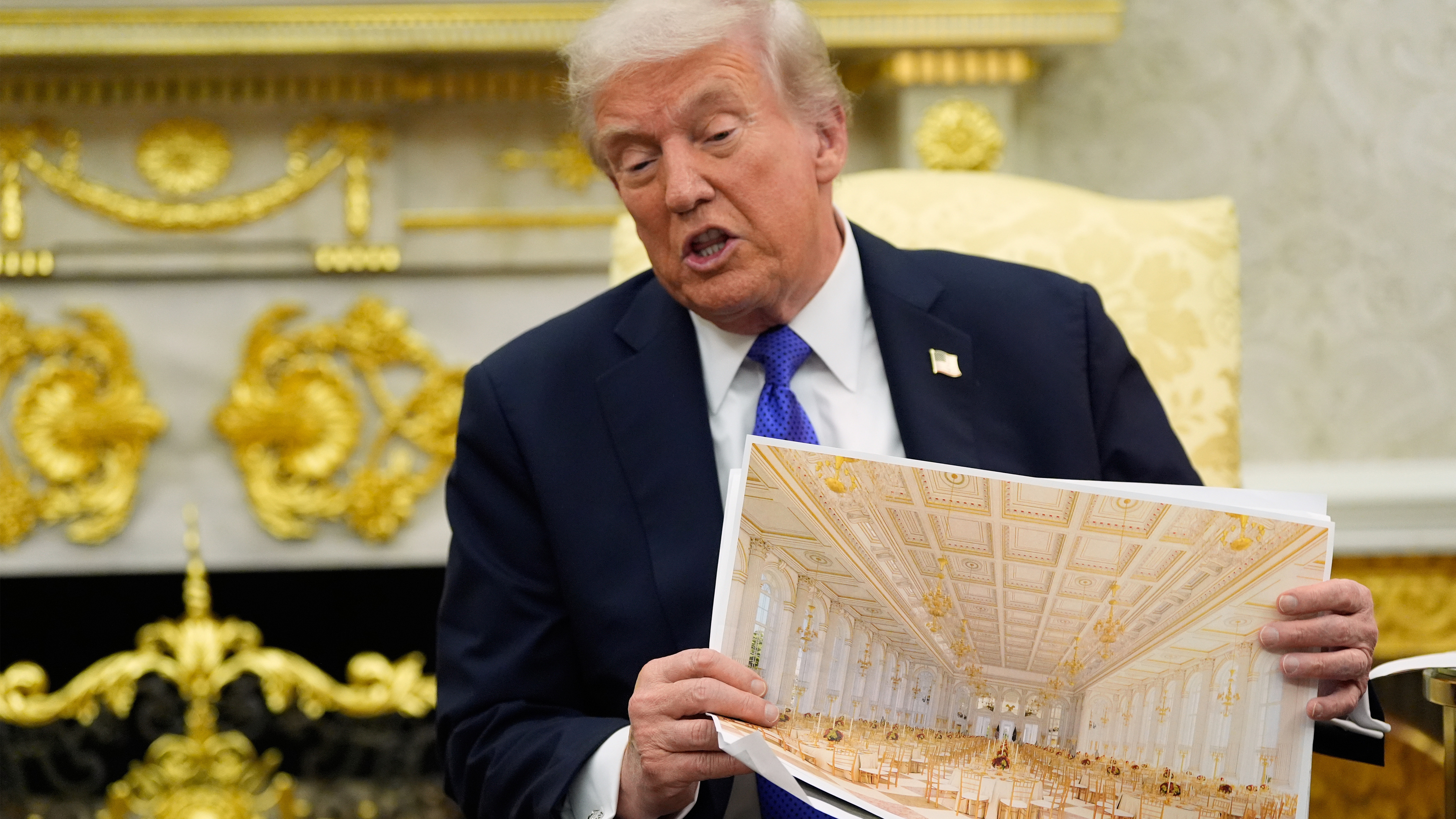 President Donald Trump holds an artist rendering of interior of the new White House ballroom as meets with NATO Secretary General Mark Rutte in the Oval Office of the White House, Wednesday, Oct. 22, 2025, in Washington. 