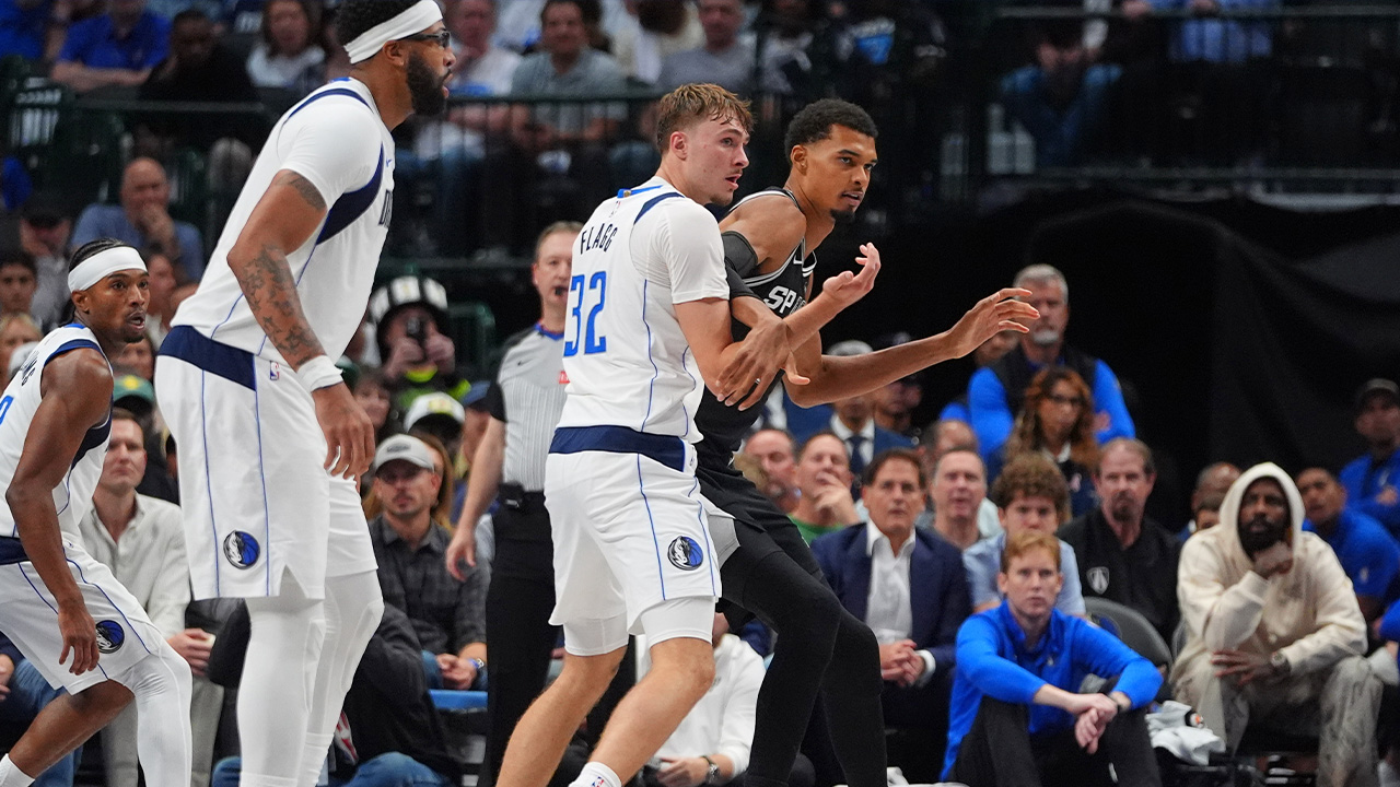 Spurs forward Victor Wembanyama, right, is defended by Mavericks forward Cooper Flagg (32) in Dallas, Wednesday, Oct. 22, 2025.