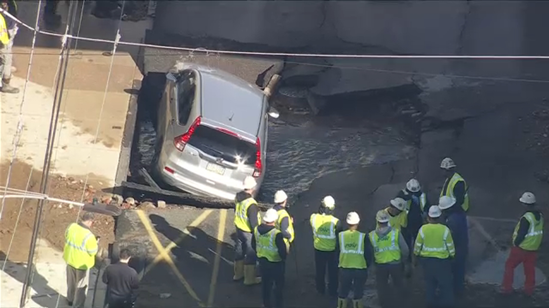Chopper 6 was above a car that could be seen barely hanging on after the roadway collapsed underneath after a water main break