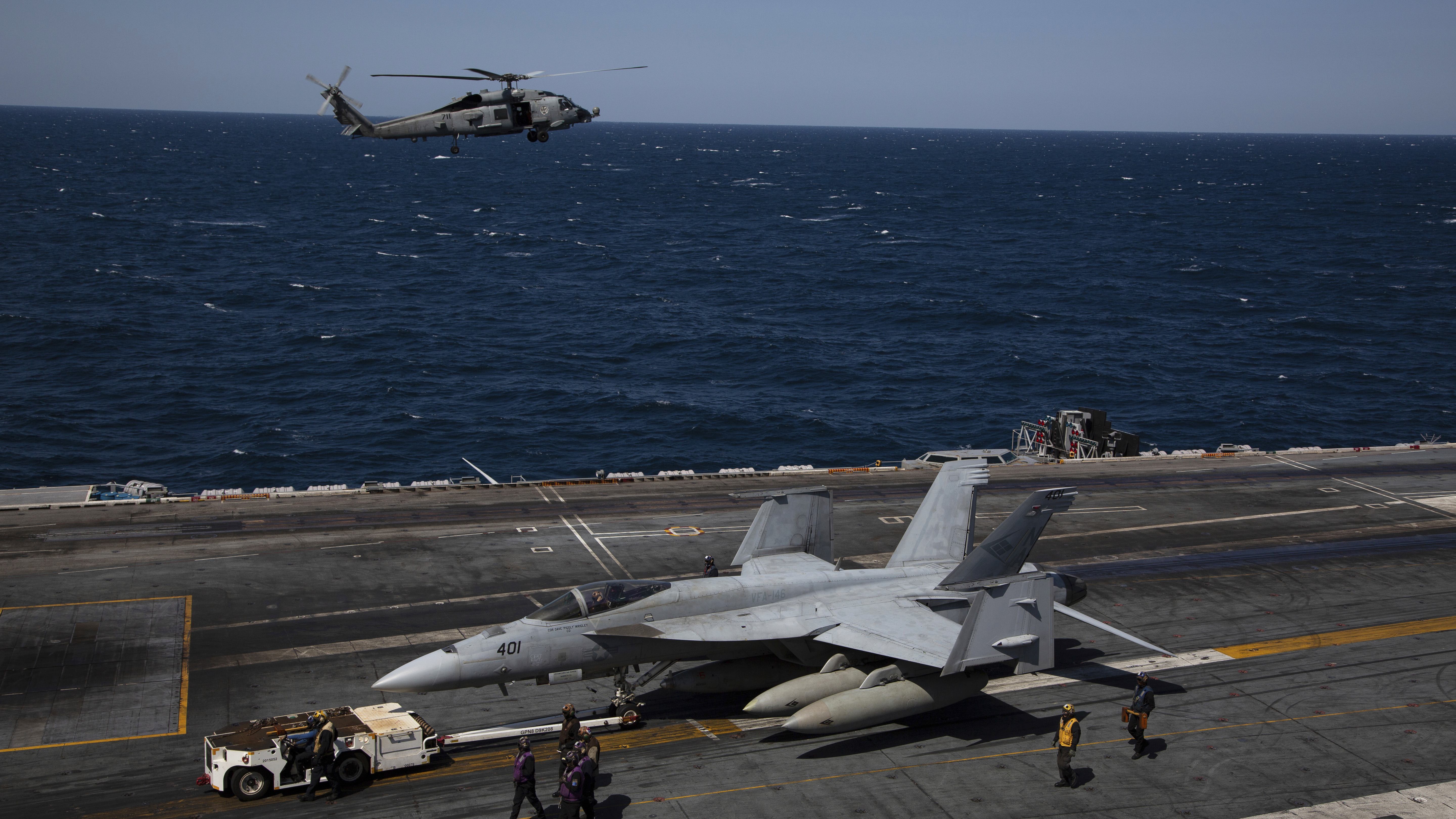 U.S. Navy MH-60S Hawk helicopter, top, and F-18 Super Hornets are seen on the flight deck of the USS Nimitz off the coast of Busan, South Korea, Monday, March 27, 2023.