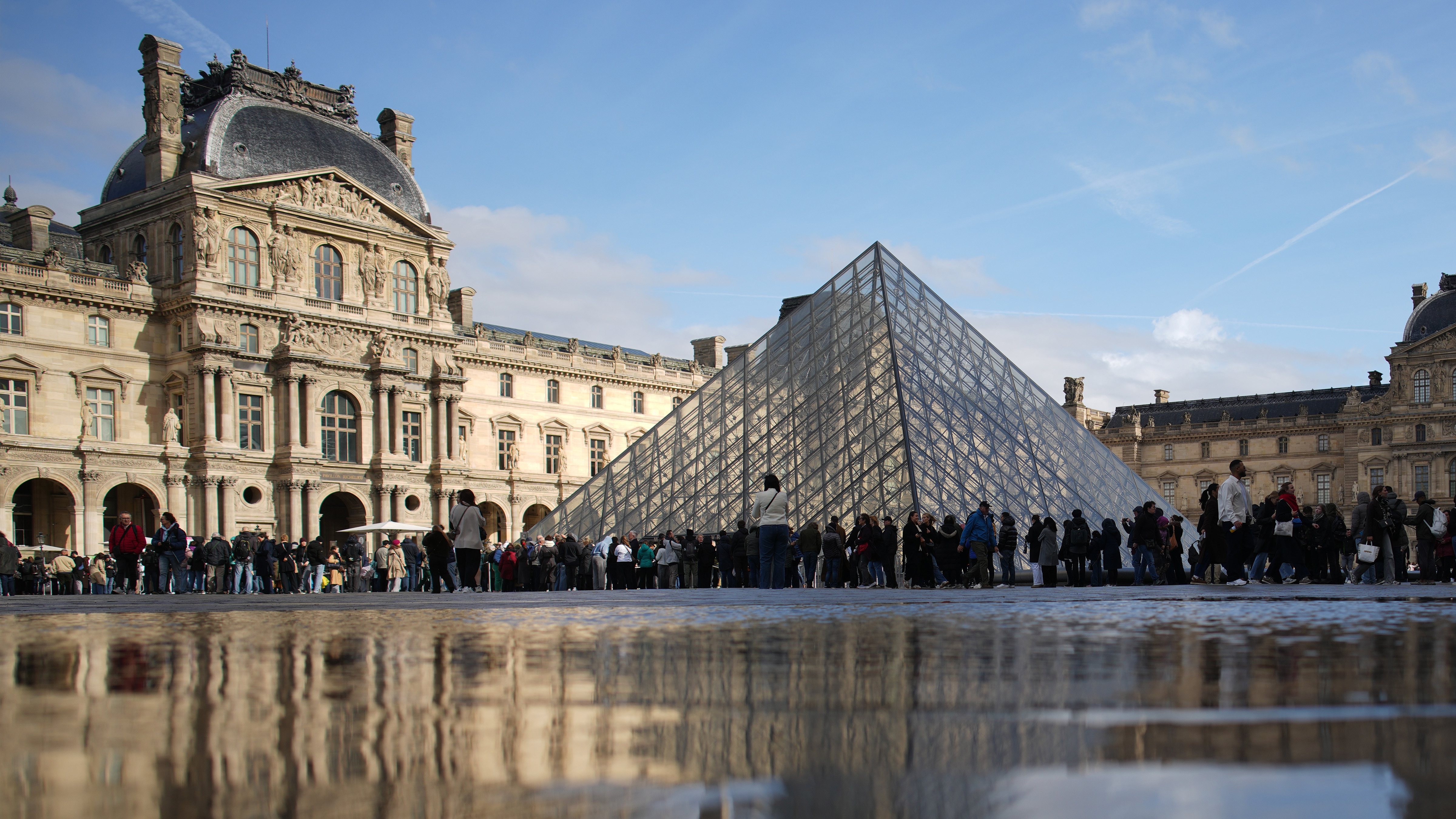 People queue to enter Le Louvre museum Monday, Oct. 27, 2025 in Paris.