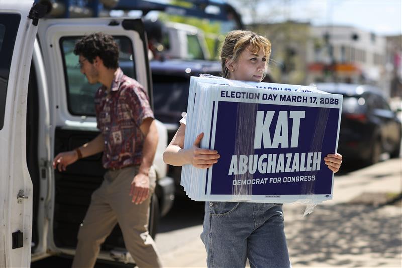 Kat Abughazaleh, who has announced a campaign for Illinois' 9th Congressional District, carries yard signs into her brand-new campaign office in Rogers Park on May 6, 2025.