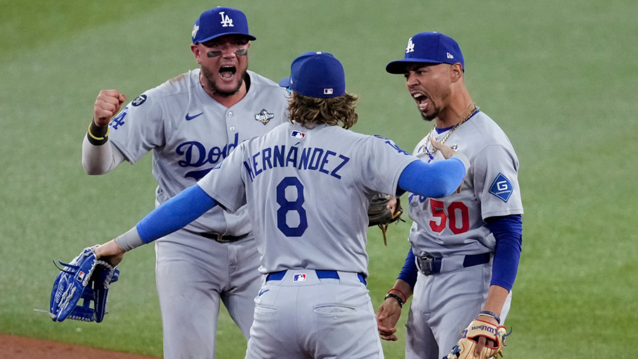 Dodgers' Mookie Betts, right, Kiké Hernández (8) as Miguel Rojas celebrate after Toronto Blue Jays' Addison Barger was forced out to end Game 6 of baseball's World Series.