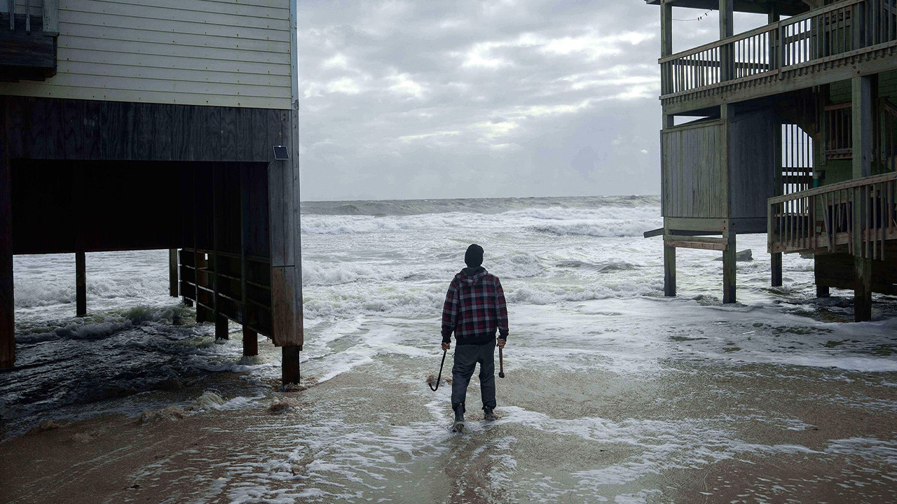A worker reinforces a home that's at risk of falling into the ocean on October 10 in Buxton, North Carolina.