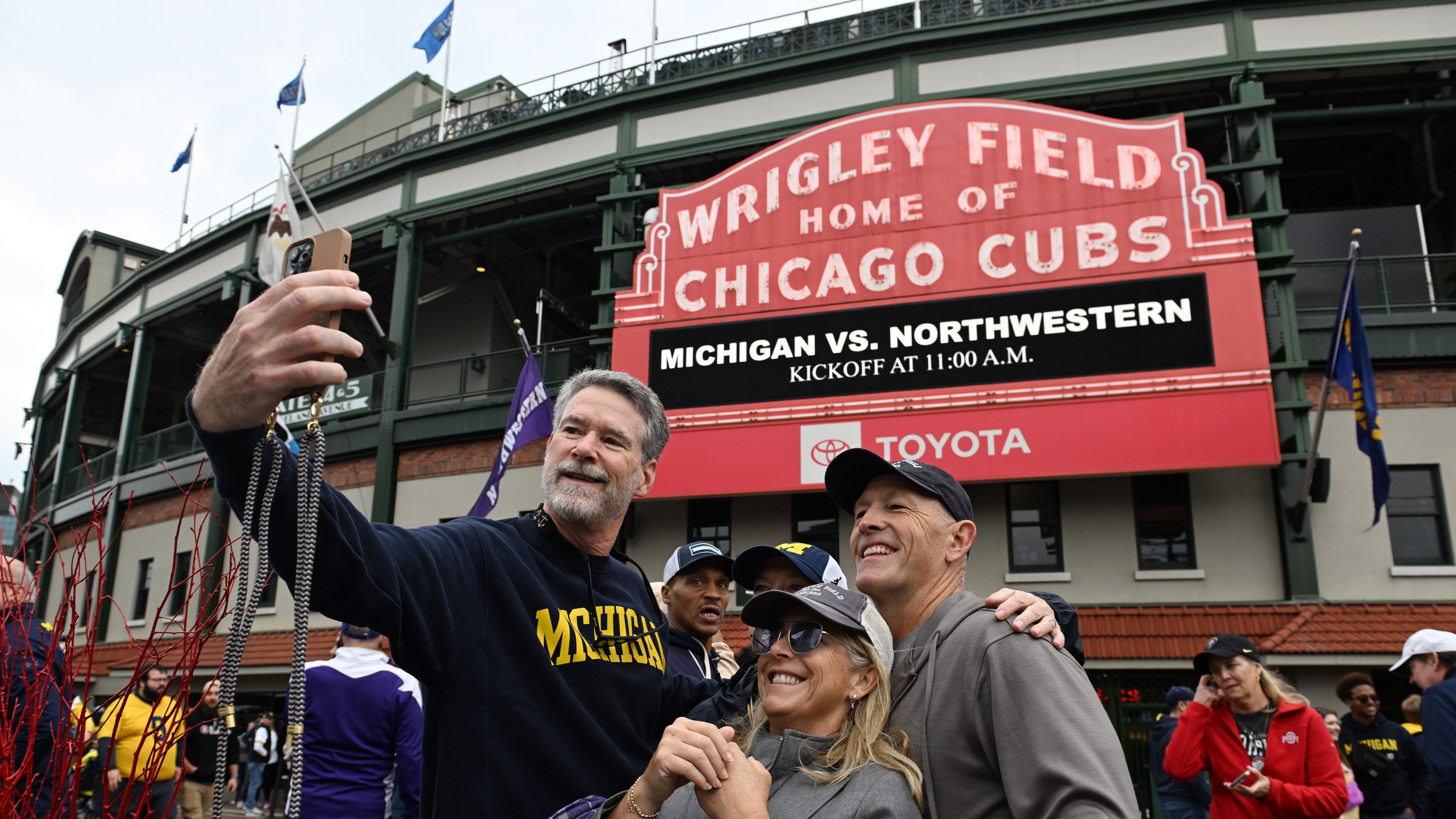 Fans take a selfie outside Wrigley Field before an NCAA football game between Northwestern and Michigan, Saturday, Nov. 15, 2025, in Chicago.