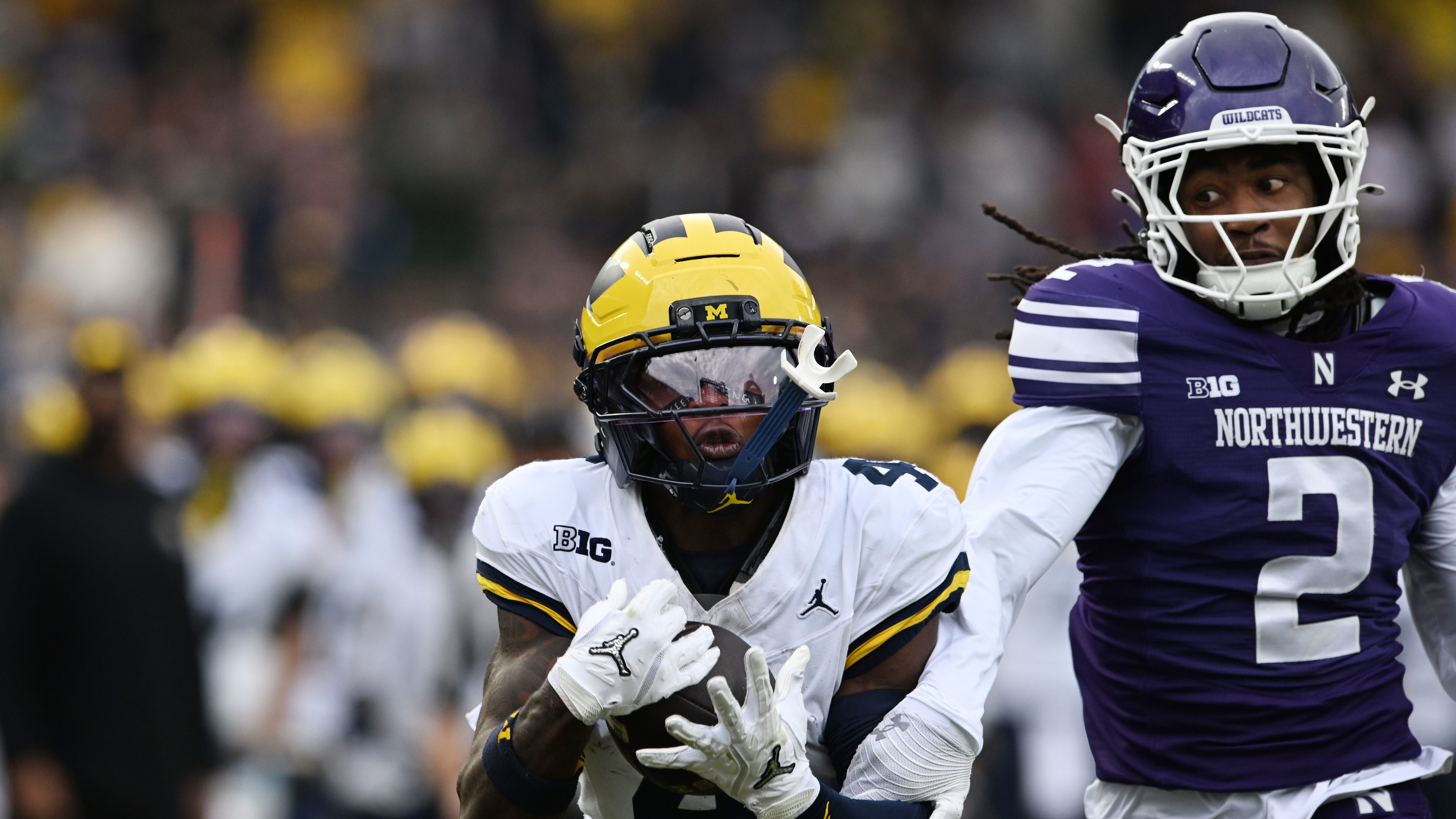 Michigan wide receiver Andrew Marsh catches a pass ahead of Northwestern's Fred Davis II during an NCAA college football game Saturday, Nov. 15, 2025, in Chicago.
