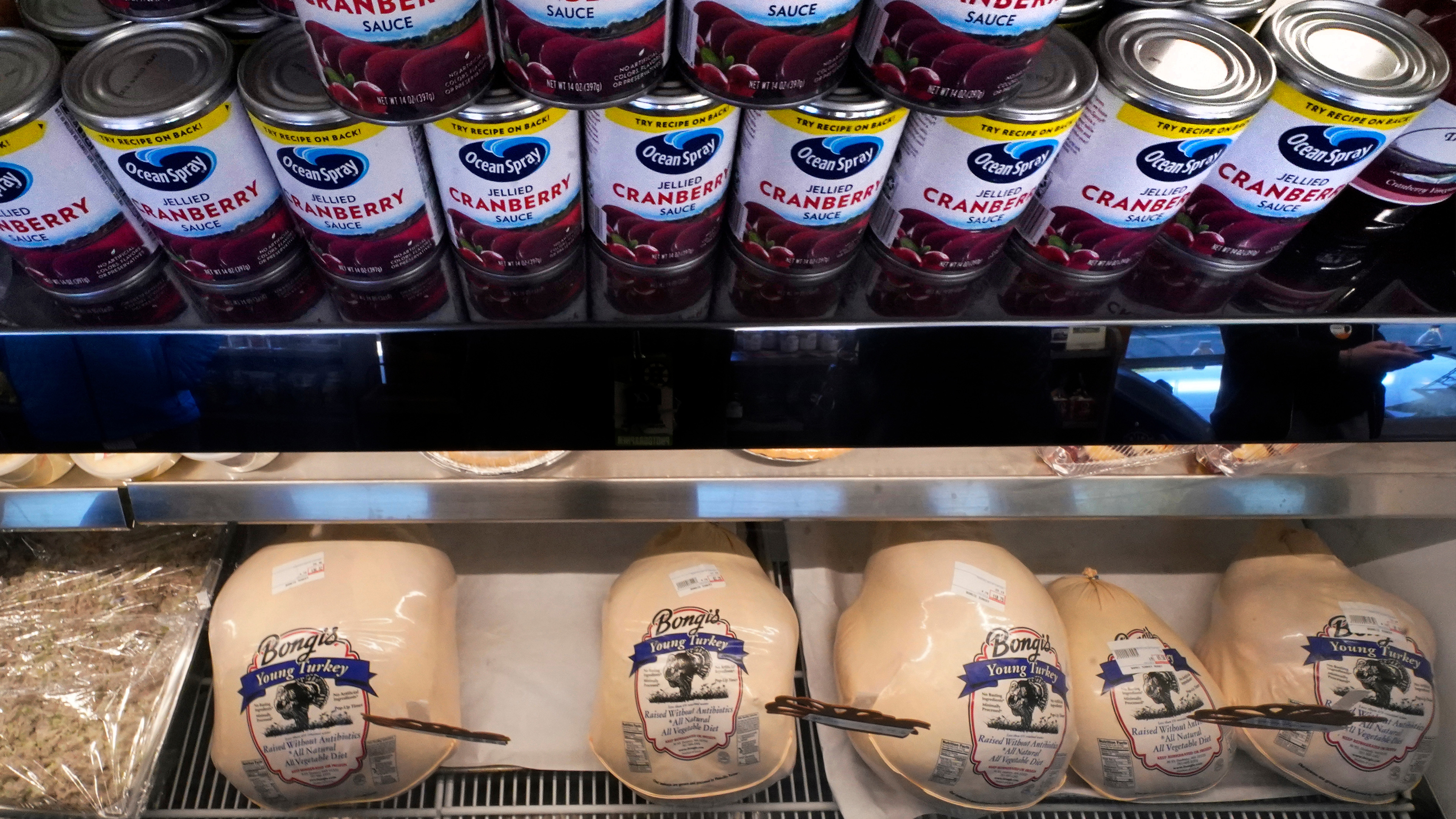 Cans of cranberry sauce line a turkey display case at Bongi's Turkey Roost in advance of the Thanksgiving holiday, Nov. 22, 2022, in Duxbury, Mass. 