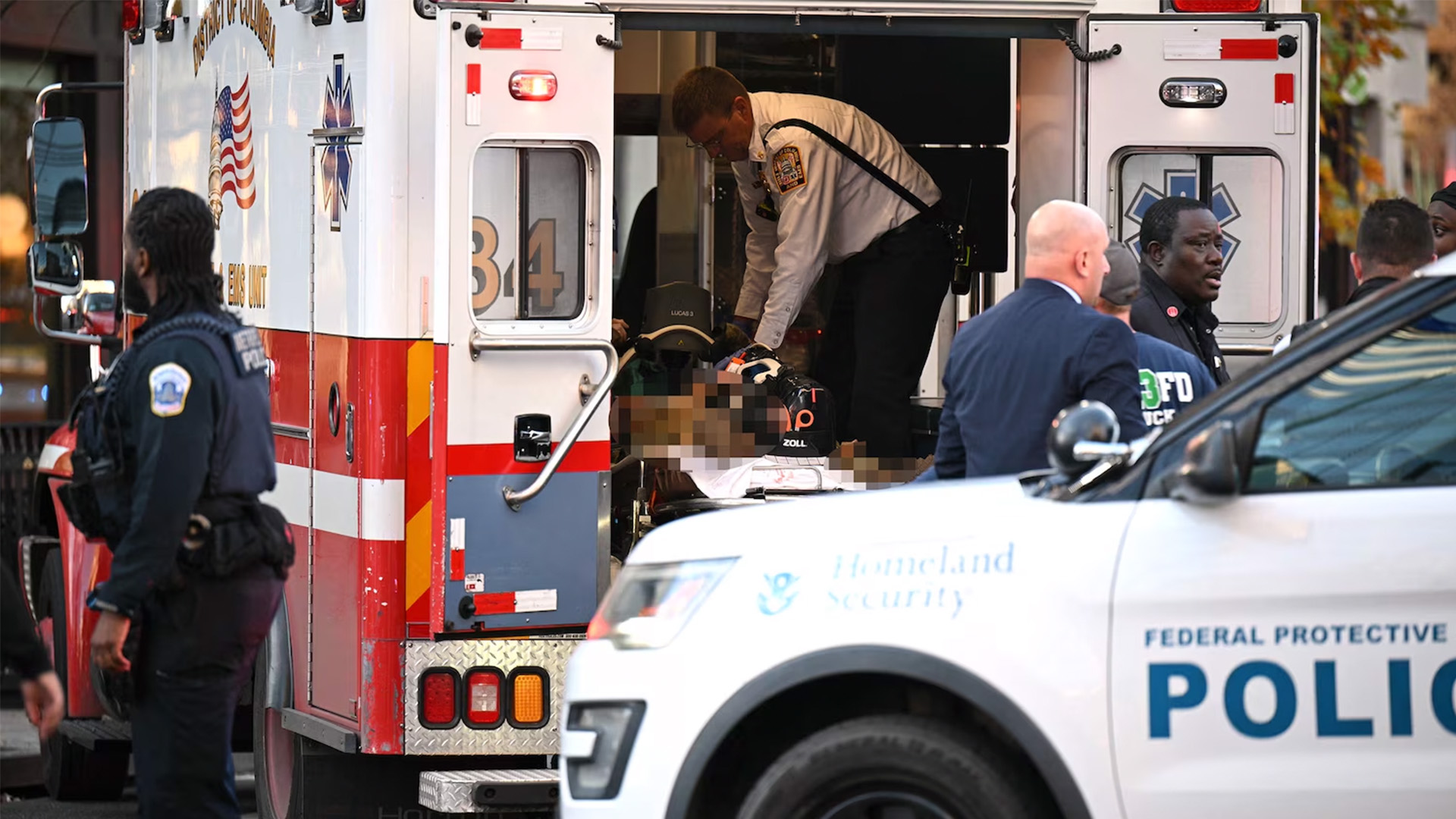 An unidentified man in military fatigues lies on a stretcher inside an ambulance, Nov. 26, 2025, in downtown Washington, D.C.