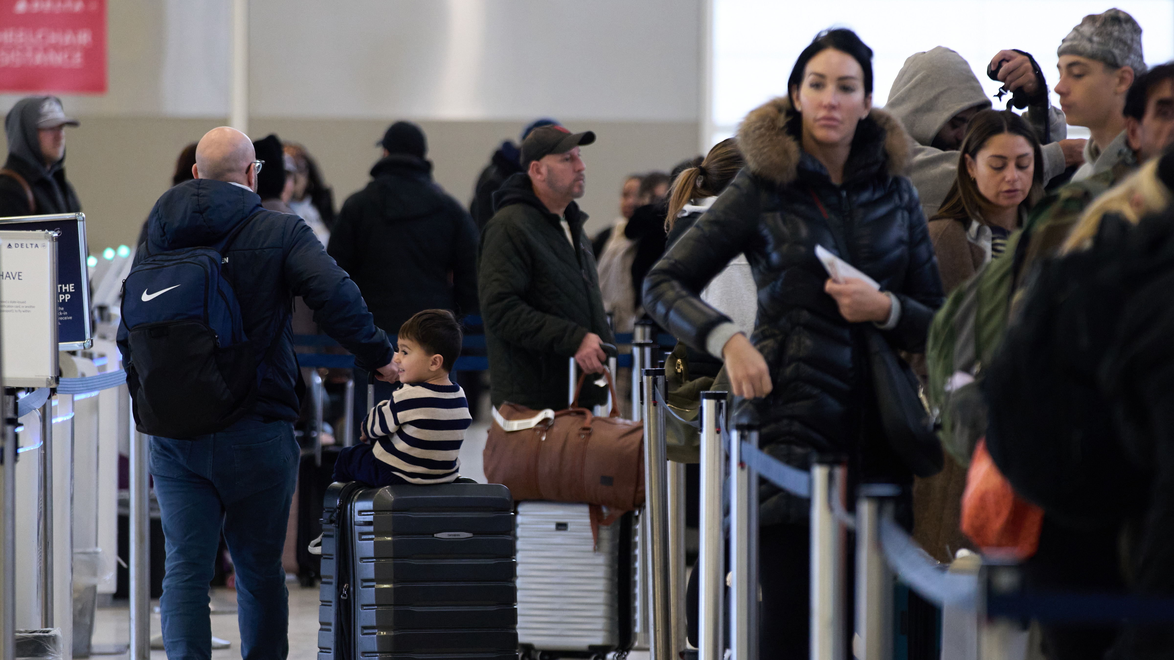 Travelers wait at a TSA security checkpoint at Detroit Metropolitan Wayne County Airport Sunday, Nov. 30, 2025, in Romulus, Mich.