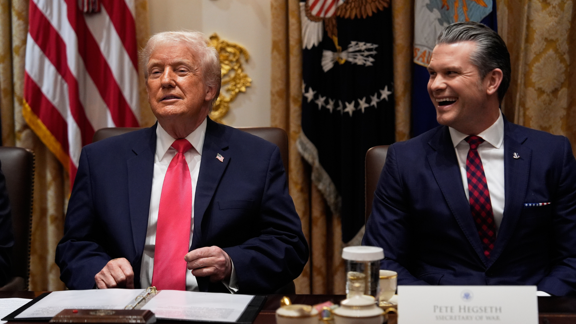 President Donald Trump speaks during a cabinet meeting at the White House, Tuesday, Dec. 2, 2025, in Washington, as Defense Secretary Pete Hegseth looks on.