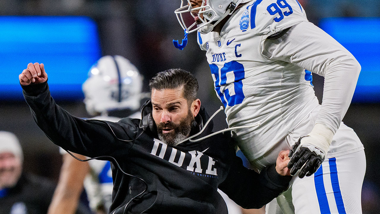L'allenatore capo della Duke Manny Diaz (a sinistra) si congratula con Aaron Hall per un contrasto difensivo dopo che Virginia ha mancato un field goal nella partita del campionato ACC a Charlotte.