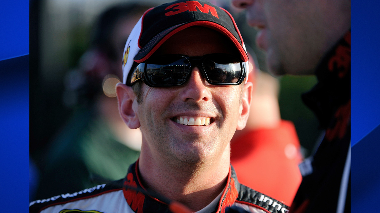 Greg Biffle smiles along pit row during qualifying for Sunday's NASCAR Sprint Cup Series auto race at Atlanta Motor Speedway, Friday, Aug. 31, 2012, in Hampton, Ga.