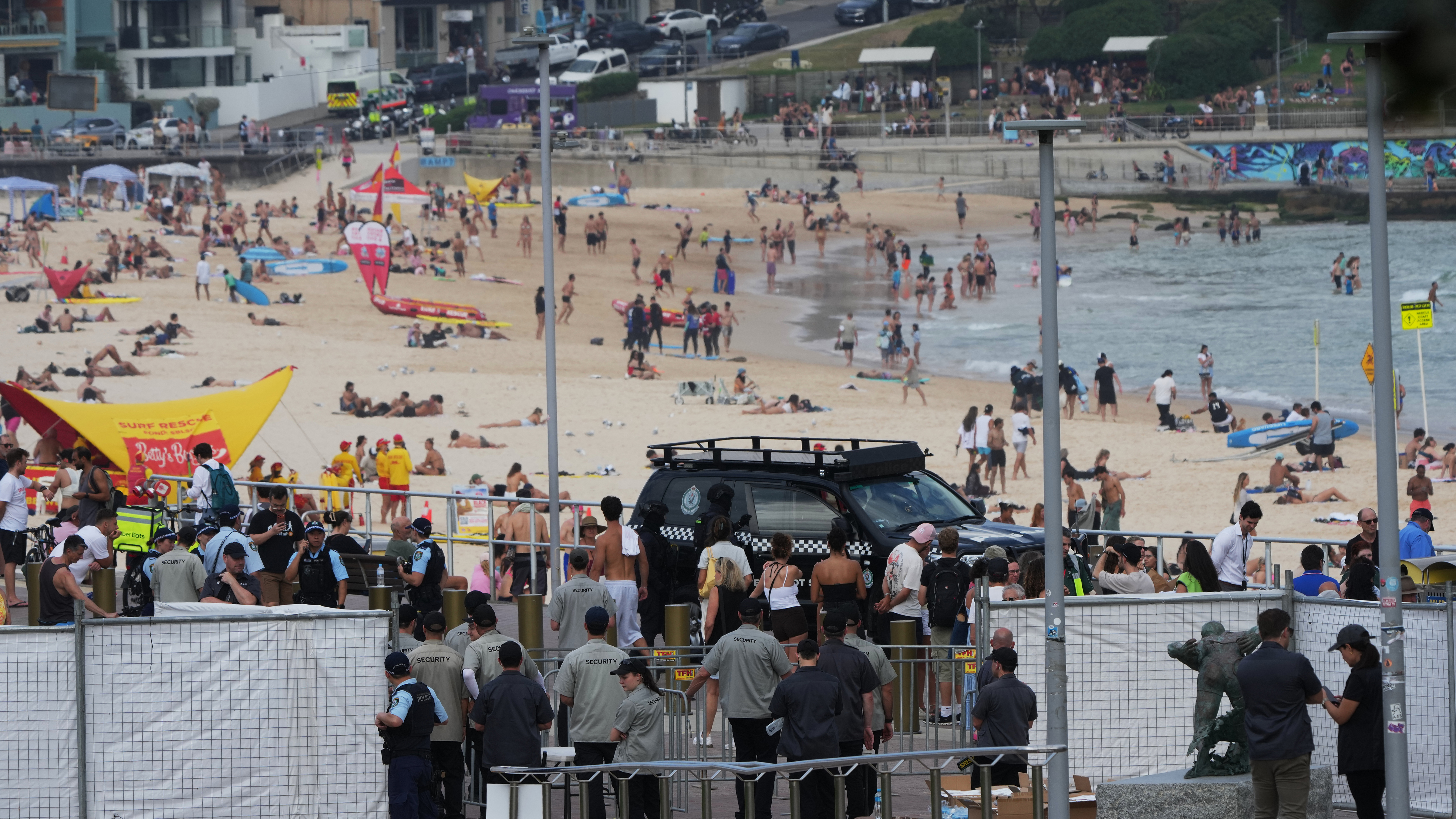 Security officers gather near a gate at Bondi Beach in Sydney, Sunday, Dec. 21, 2025, ahead of a ceremony to mark the National Day of Reflection for victims and survivors from the Bondi shooting on Dec. 14.