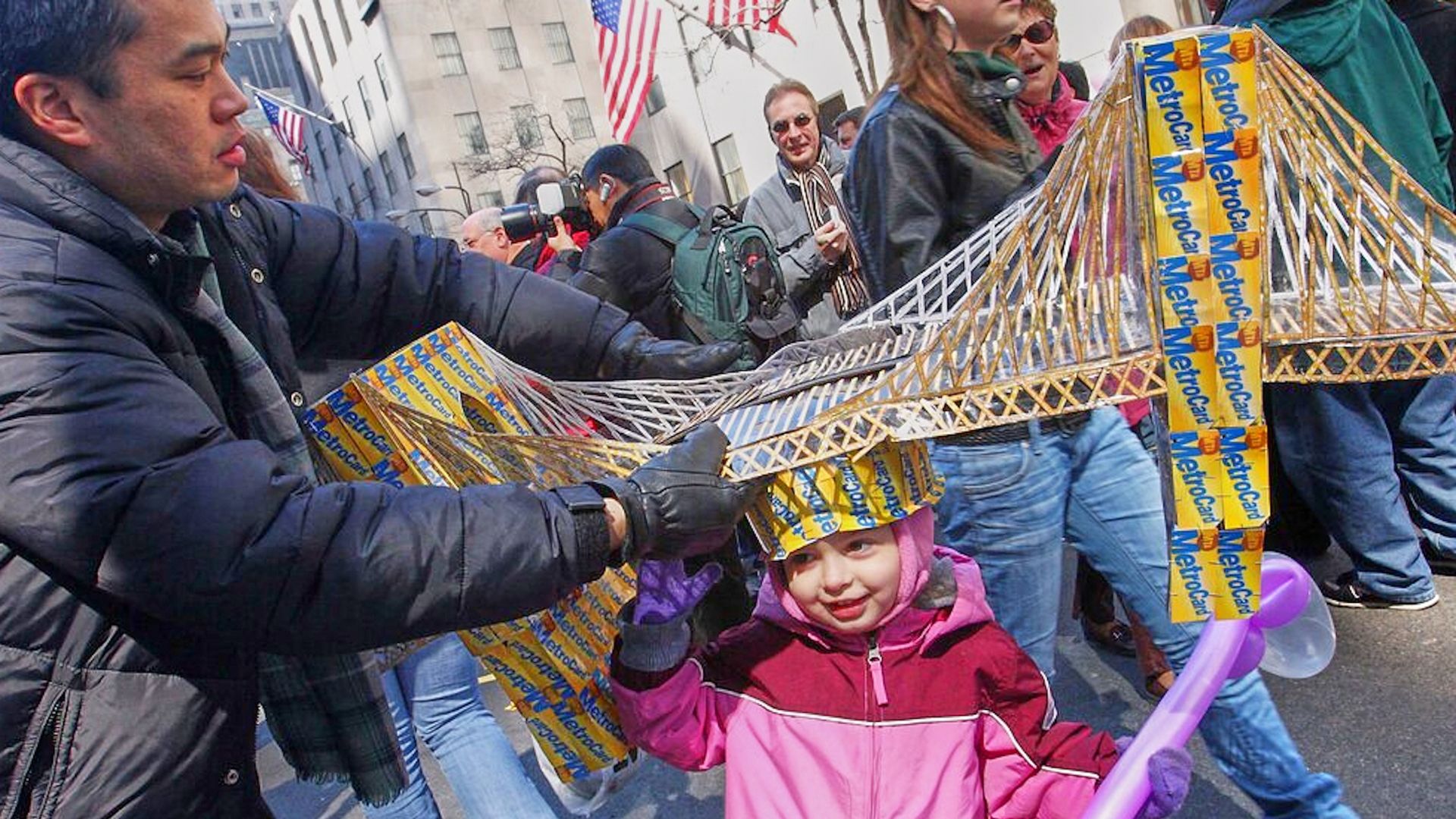 Russell Chin, left, helps Angie Hoyle, 3, as she tries on a hat made of MetroCards shaped as the Brooklyn Bridge during the Easter Parade on New York's 5th Avenue, March 23, 2008.