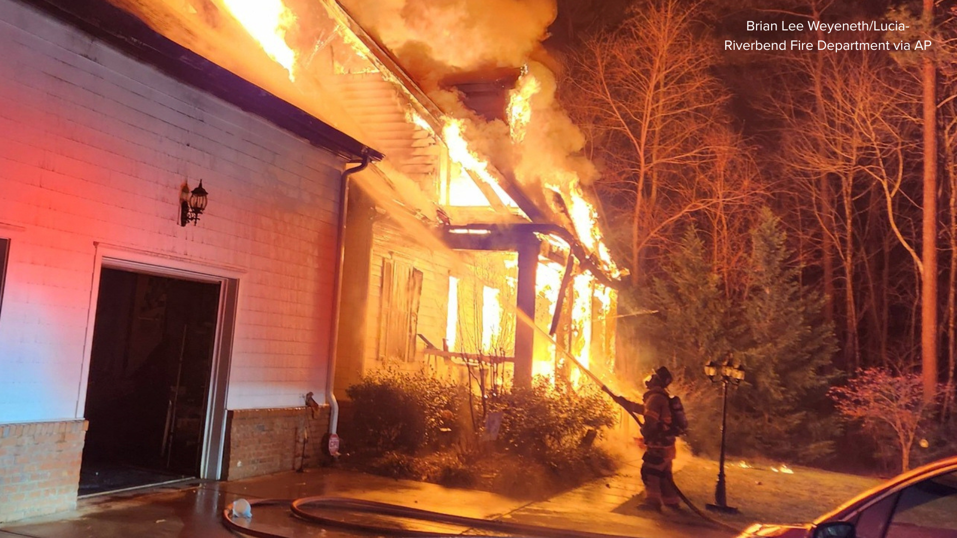 This photo provided by Lucia-Riverbend Fire Department, firefighters battle flames from a house fire late Sunday, Dec. 28, 2025 in Stanley, NC.