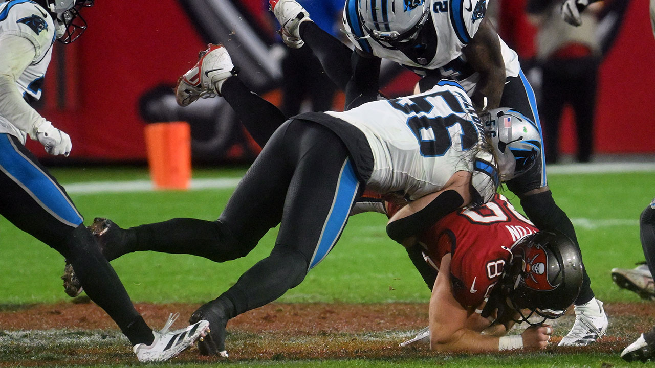 Tampa Bay Buccaneers tight end Cade Otton is tackled by Carolina Panthers linebacker Christian Rozeboom (56) and safety Nick Scott (21) on Saturday in Tampa.