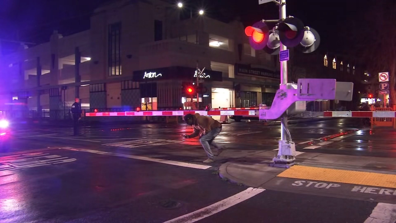 A person can be seen ducking under a San Mateo railroad crossing arm, which was stuck in a down position for hours.