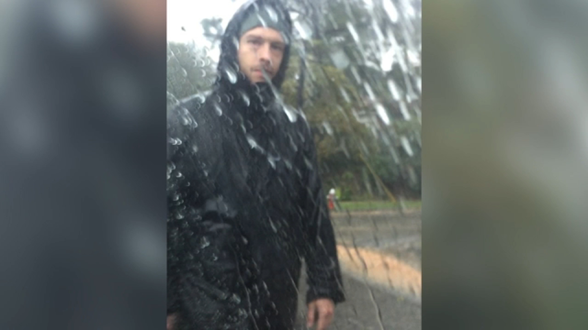 Ryan Camacho is seen in this image walking through a neighborhood in pouring rain.