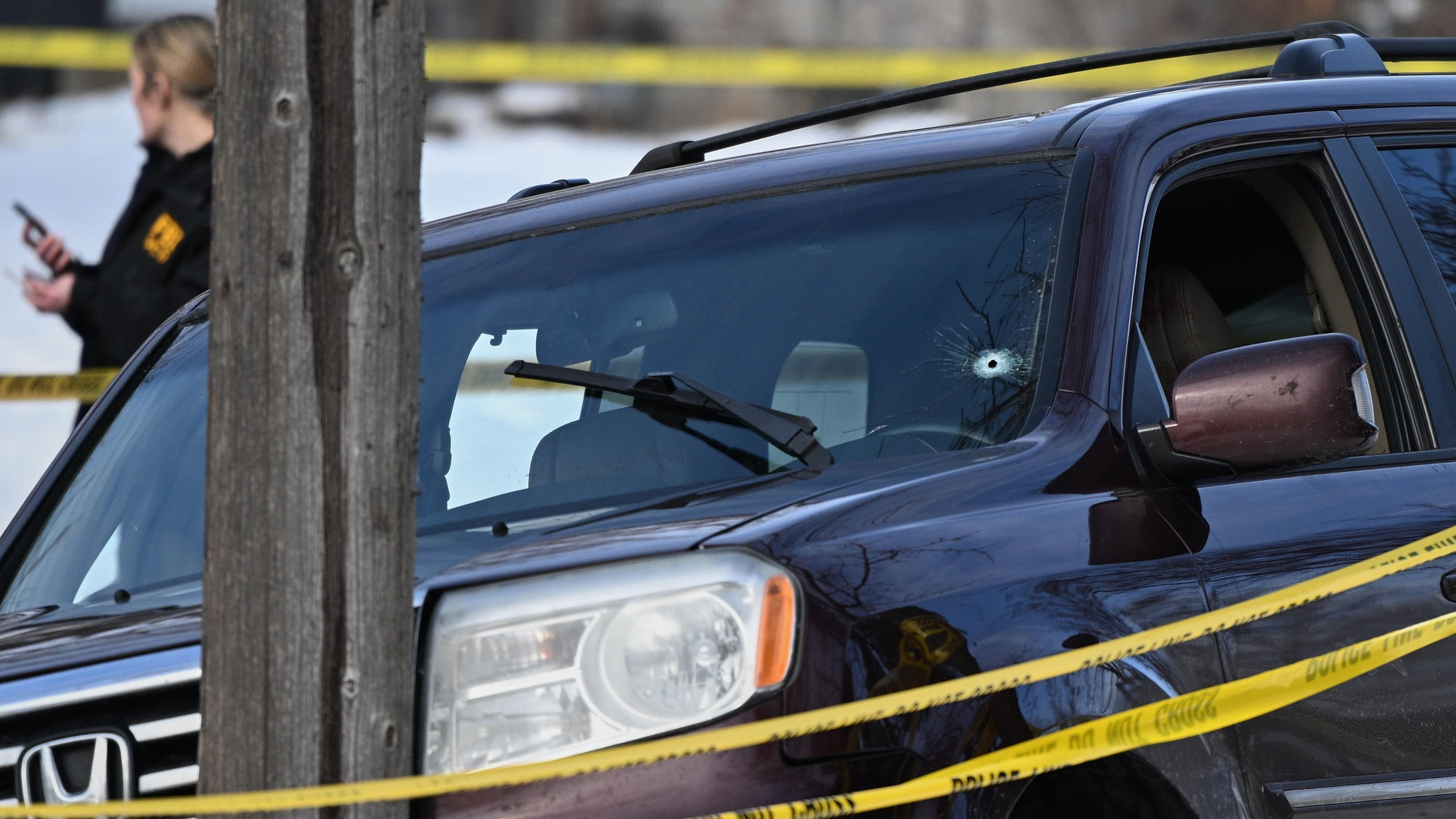 A bullet hole is seen in the windshield as law enforcement officers work at the scene of a shooting involving federal law enforcement agents, Wednesday, Jan. 7, 2026, in Minneapolis.