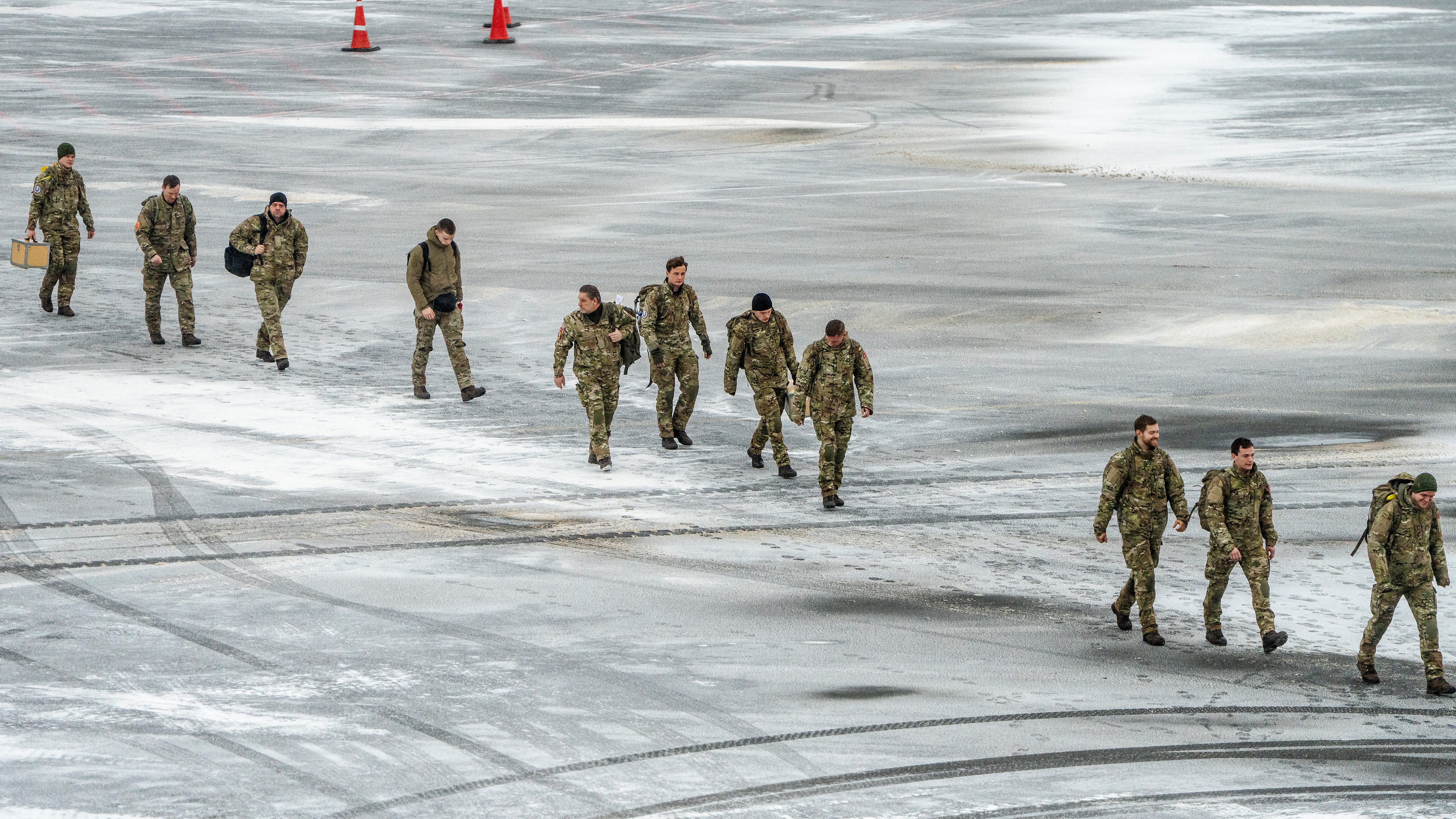 Danish soldiers walk across the frozen tarmac after arriving at Nuuk airport, Greenland, on January 19, 2026. 