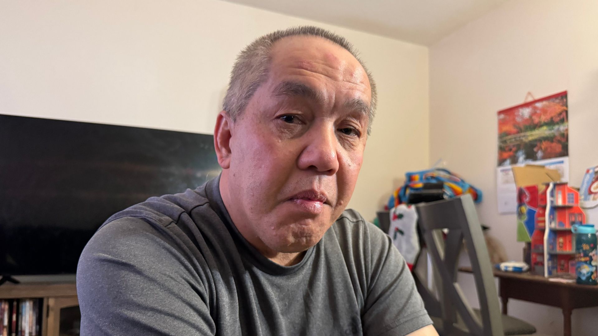 Chongly "Scott" Thao, a U.S. citizen, sits for a photo at his home in St. Paul, Minn., the day after federal agents broke open his door and detained him without a warrant.