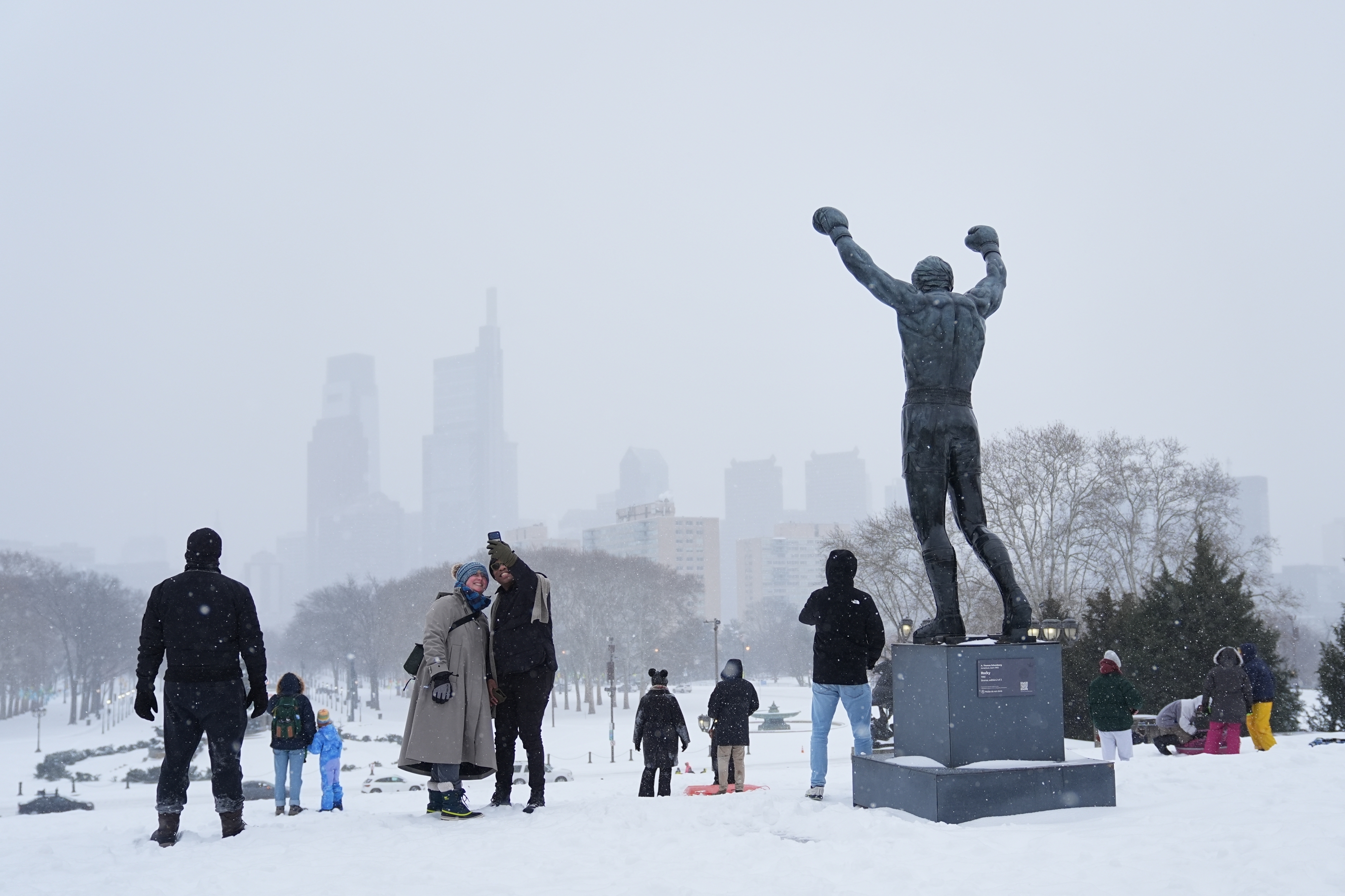 People sled at Philadelphia Art Museum steps by the Rocky statue during a winter storm on Sunday, Jan. 25, 2026.