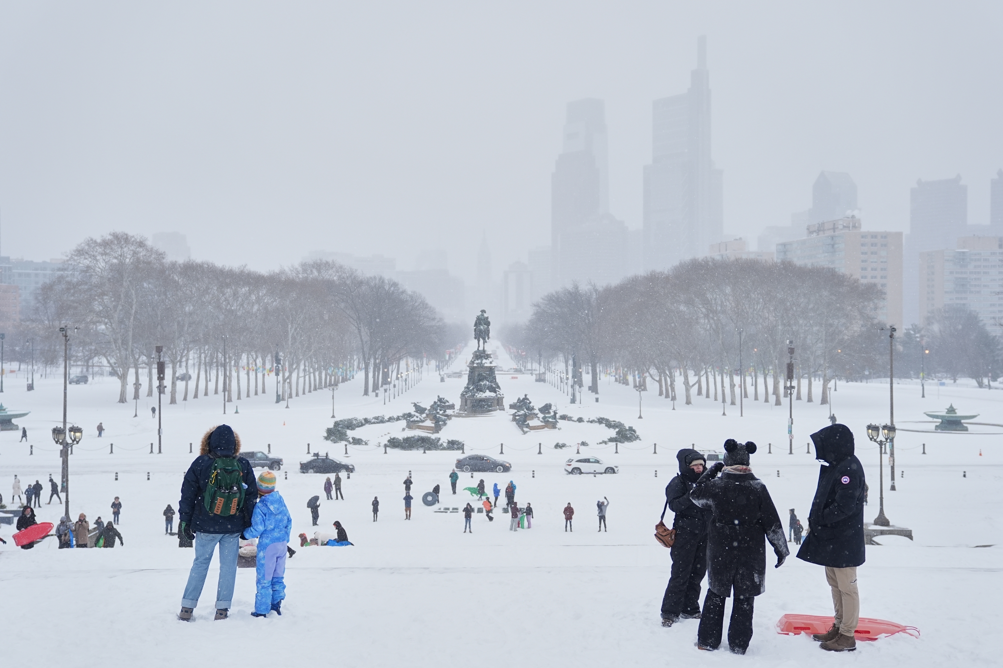 People sled at Philadelphia Art Museum steps by the Rocky statue during a winter storm on Sunday, Jan. 25, 2026.