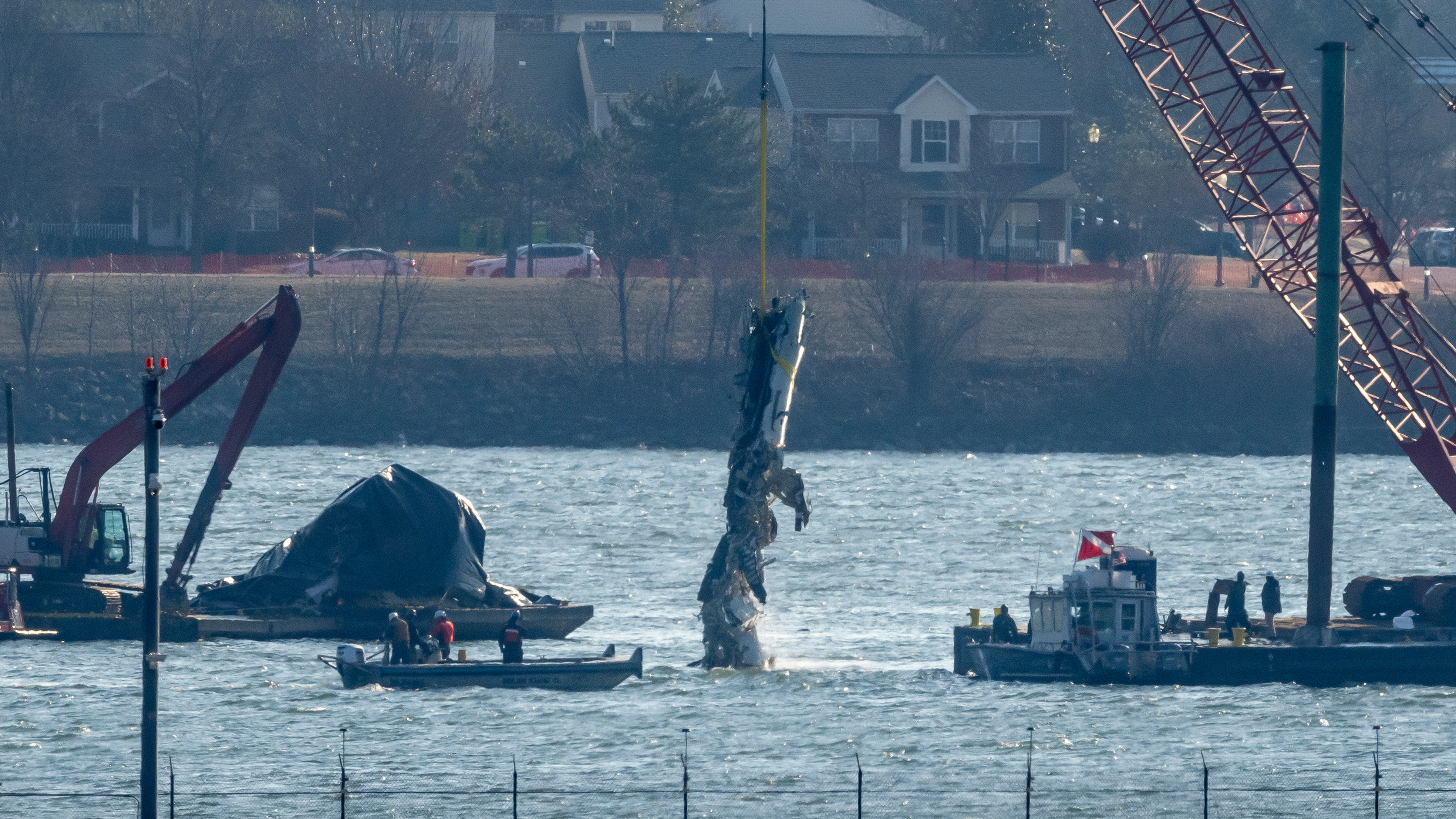 A piece of wreckage is lifted from the water onto a salvage vessel near the site of a mid-air collision between an American Airlines jet and a Black Hawk helicopter, at Ronald Reagan Washington National Airport, Feb. 4, 2025, in Arlington, Va.