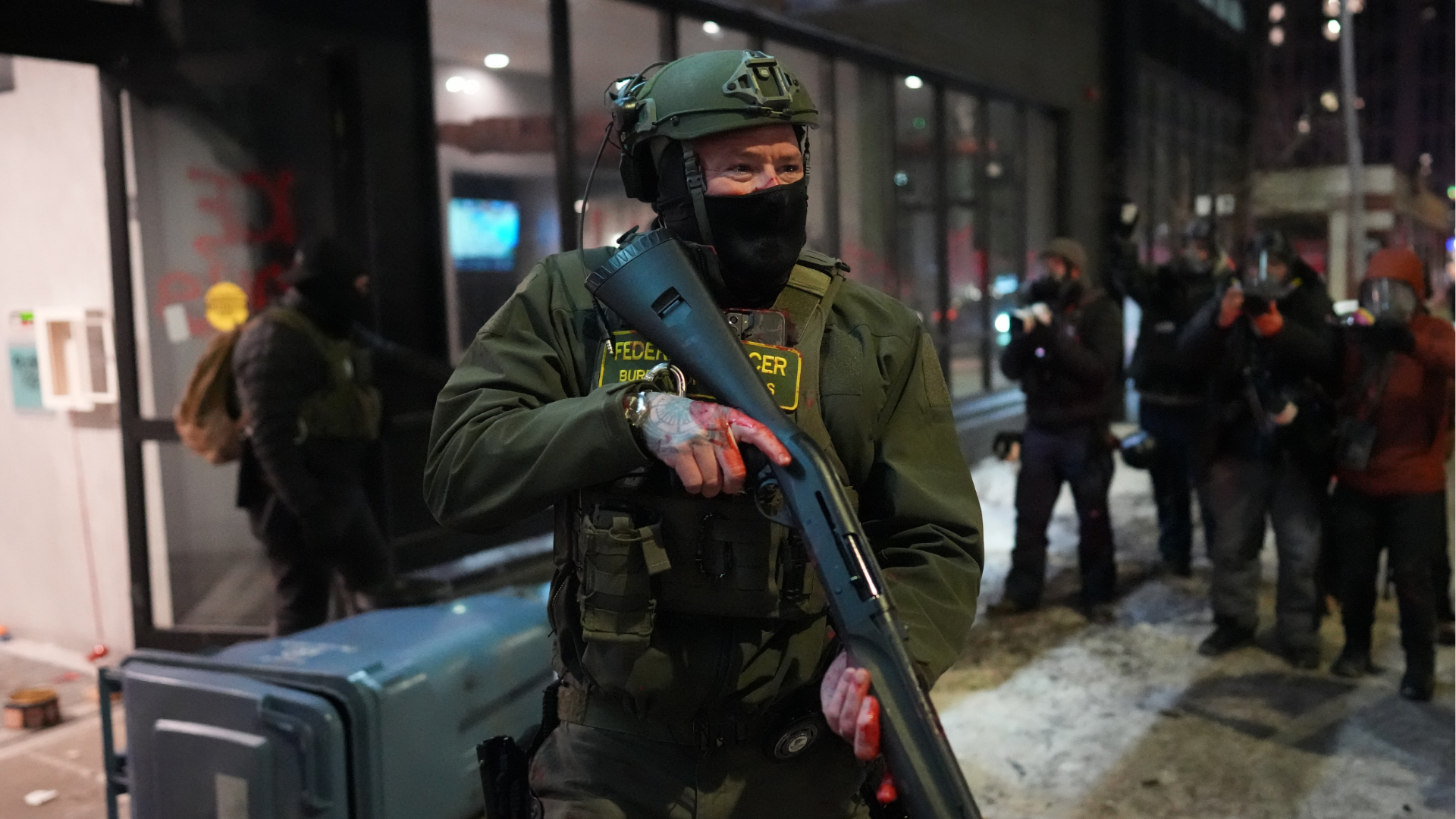 A federal agent stands guard near a hotel during a noise demonstration protest in response to federal immigration enforcement operations Sunday, Jan. 25, 2026, in Minneapolis.