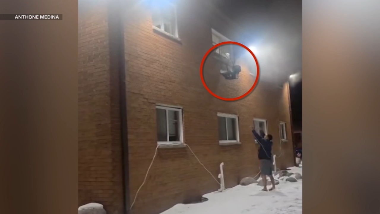 Dramatic video shows a baby in a carrier being lowered from an apartment building that was on fire.
