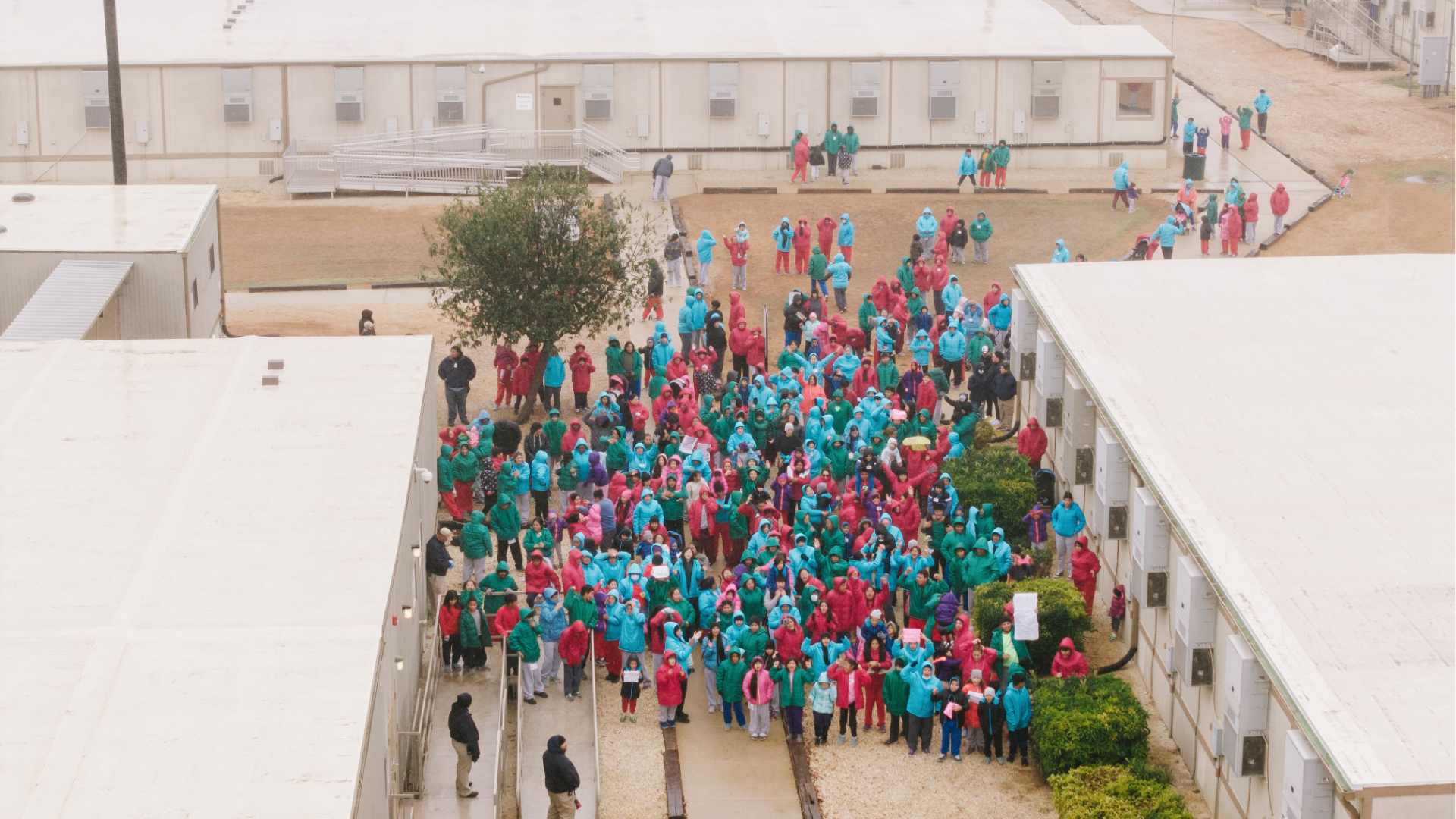 Detainees held at the South Texas Family Residential Center wave signs during a demonstration in Dilley, Texas, Saturday, Jan. 24, 2026.