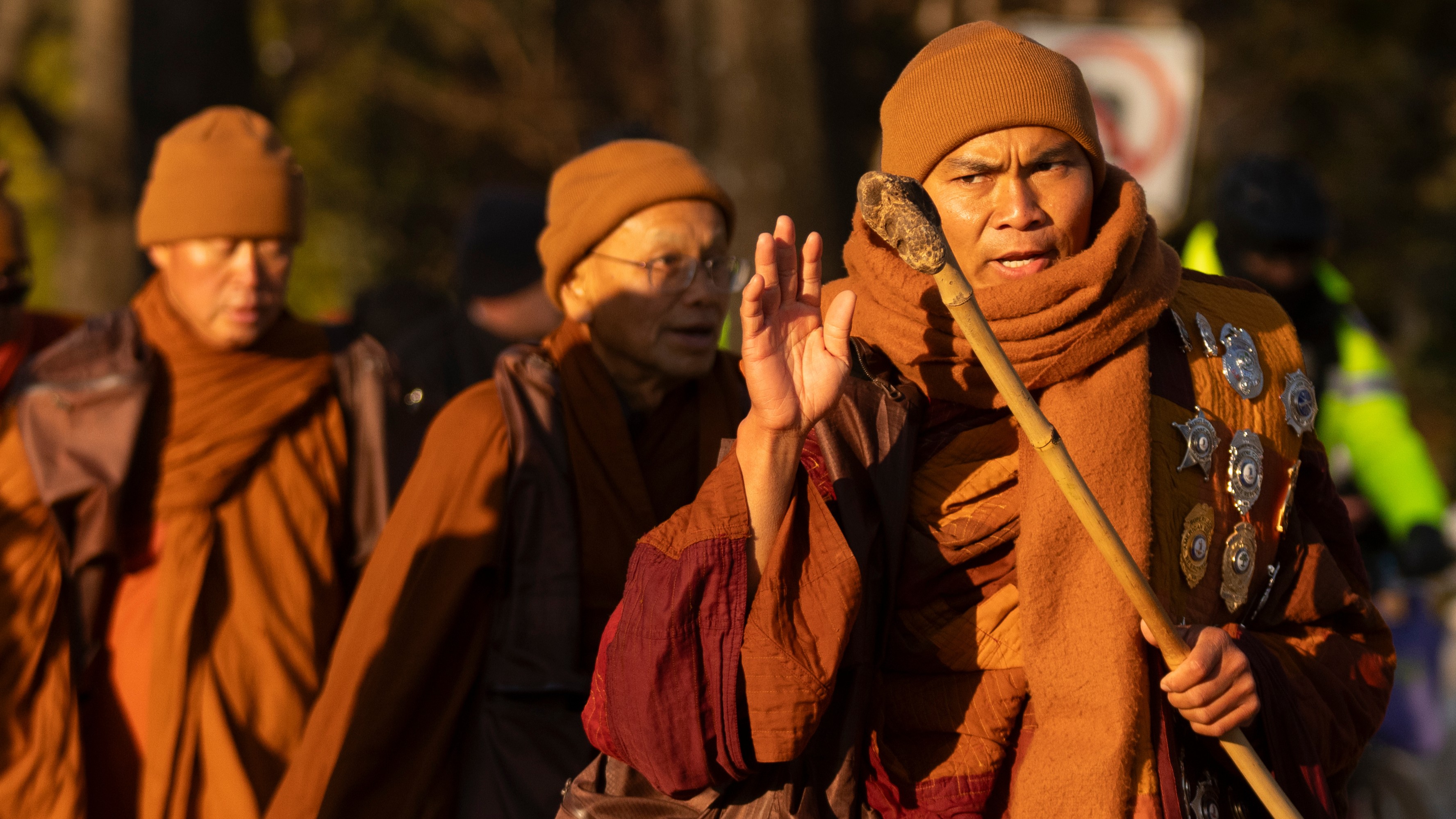 Monk Bhikku Panakkara waves as Buddhist monks participating in a peace march walk through a neighborhood Tuesday, Feb. 10, 2026, in Washington.