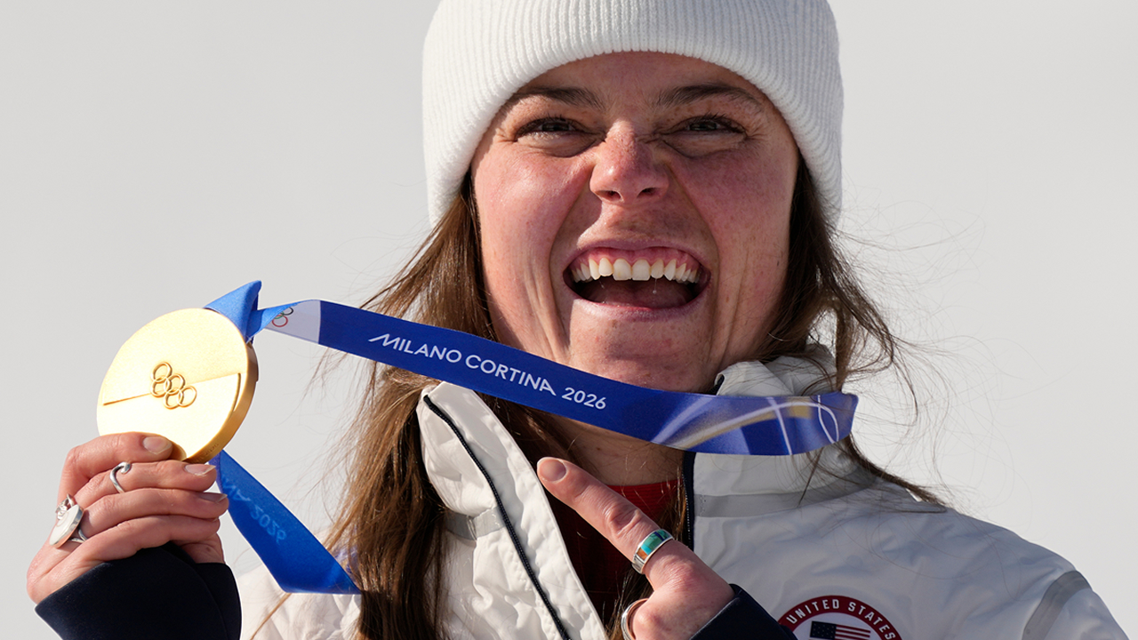 United States' Breezy Johnson shows her gold medal in the alpine ski women's downhill race, at the 2026 Winter Olympics, in Cortina d'Ampezzo, Italy, Sunday, Feb. 8, 2026. 