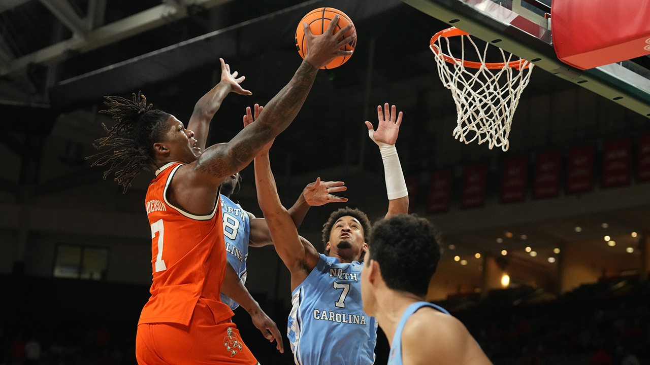 Miami forward Shelton Henderson glides over several UNC defenders, including Seth Trimble (7), on Tuesday night in Coral Gables, Florida.