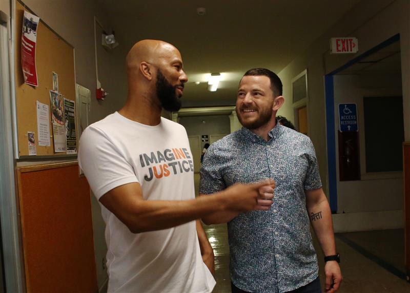 Michaell Latt (right) walking and talking with friend and collaborator Common (left)