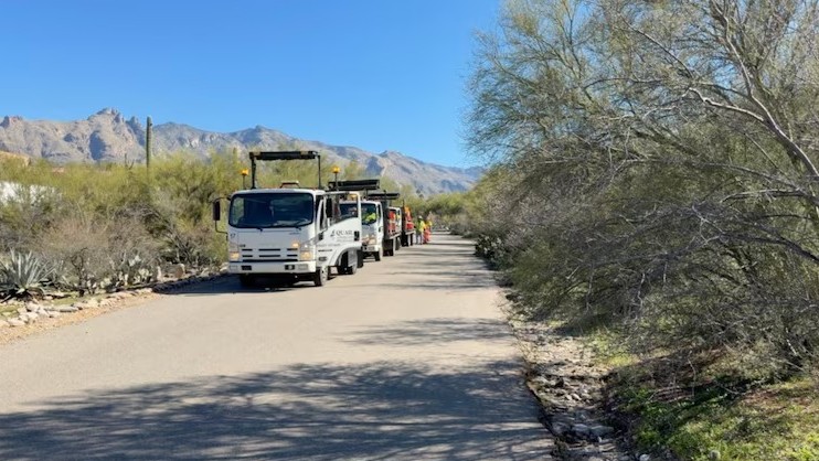 Work crews put up traffic barriers near the home of Nancy Guthrie.