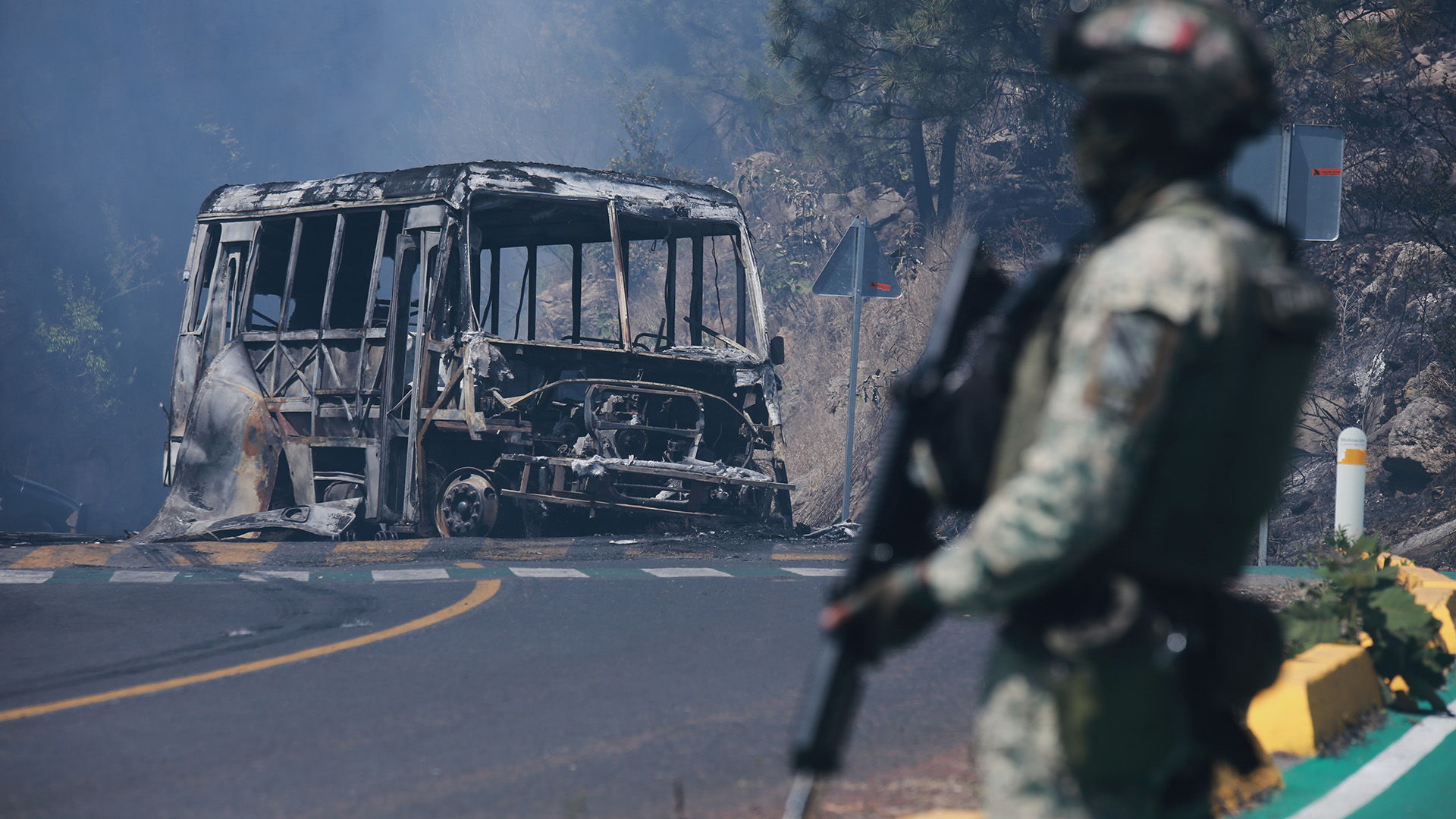 Soldado en guardia ante un auto calcinado en Cointzio, Michoacán, 22 de febrero de 2026, tras la muerte del líder del Cártel Jalisco Nueva Generación, Nemesio Oseguera, "El Mencho"