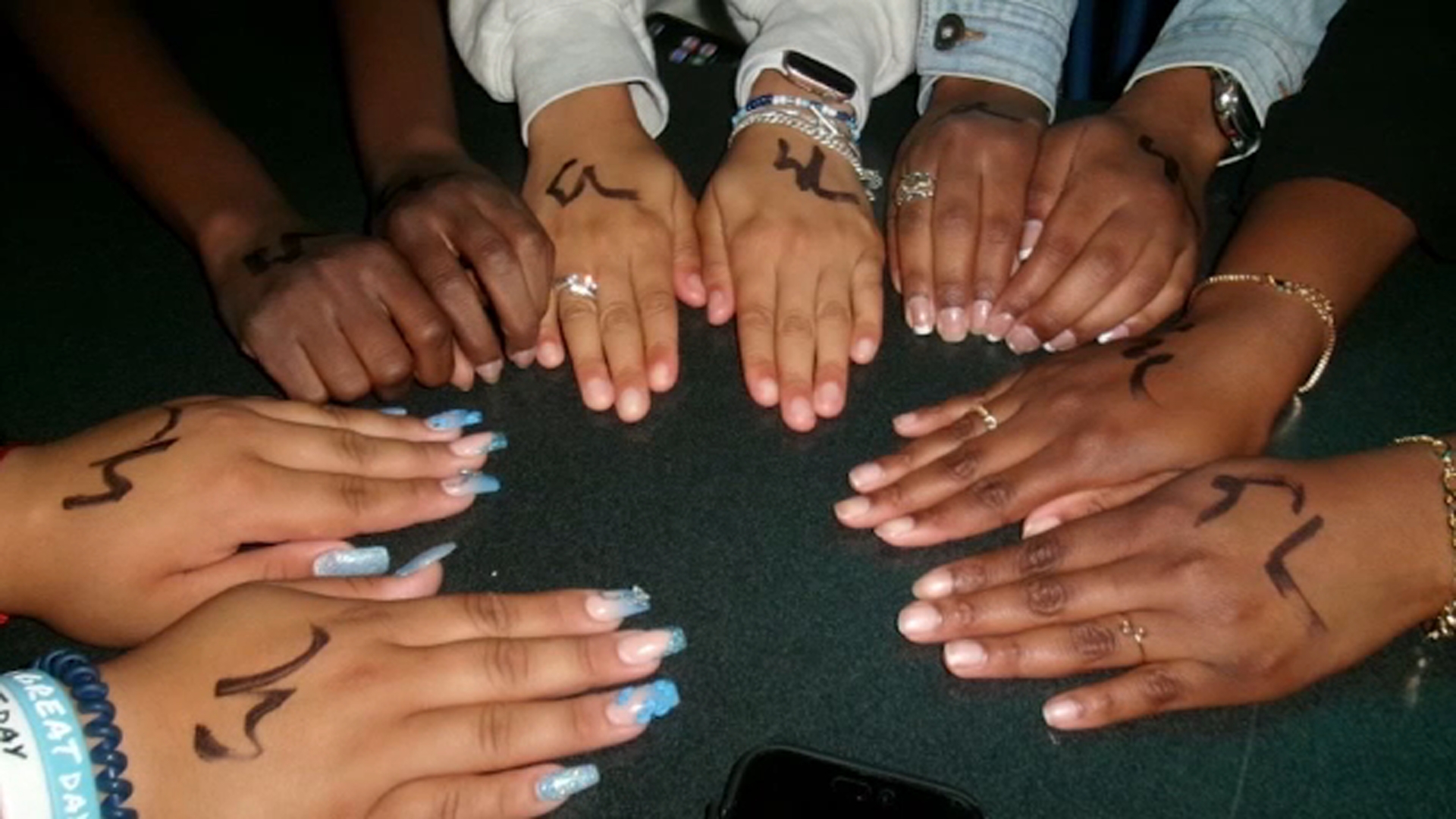 Patrons at Still Life show their hand markings that indicate they are younger than 21.