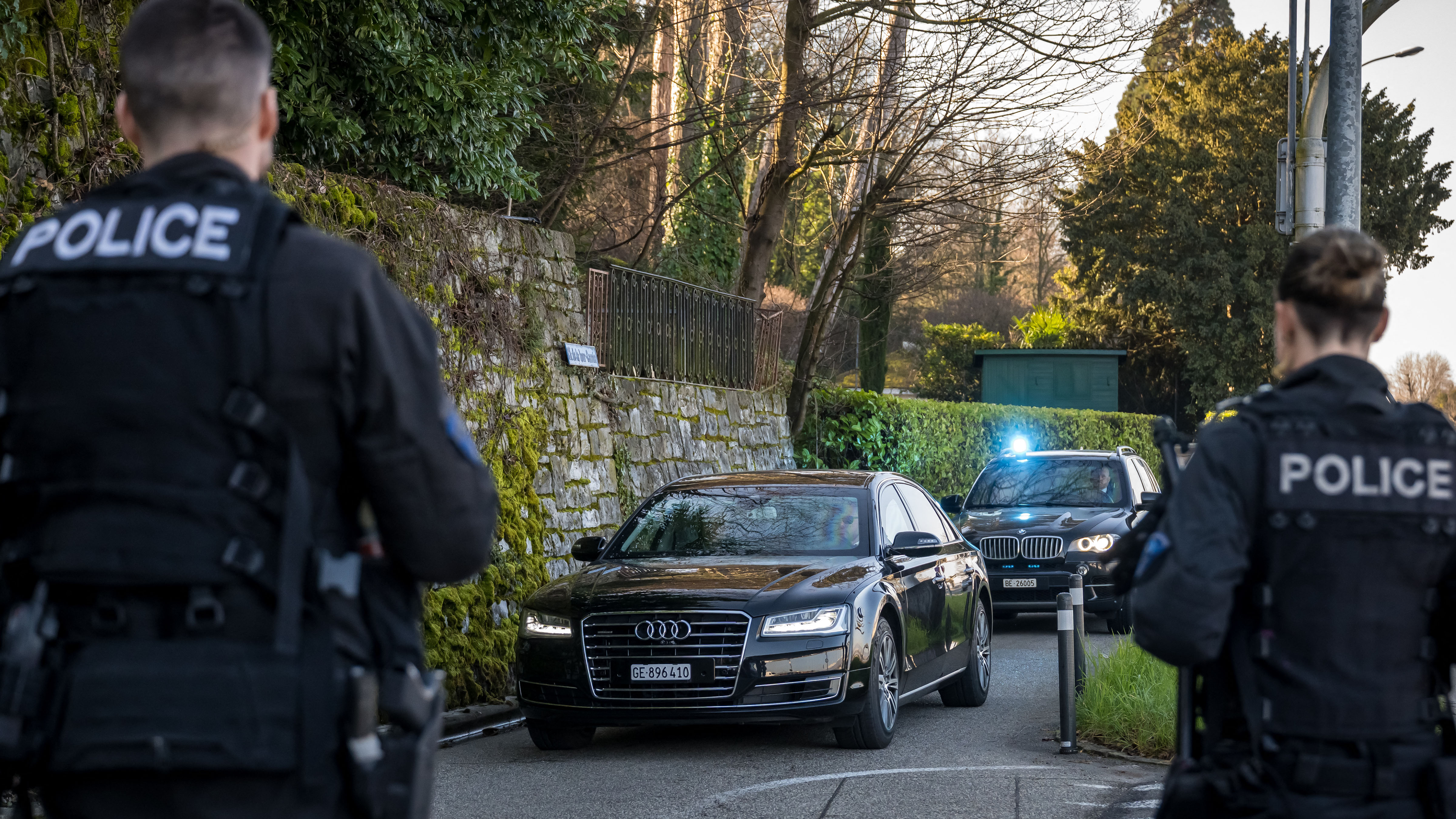 Police officers stand by as a convoy arrives at the Oman's ambassador residency for new round of talks between the United States and Iran to address Iran's nuclear program, in Geneva on February 26, 2026. 