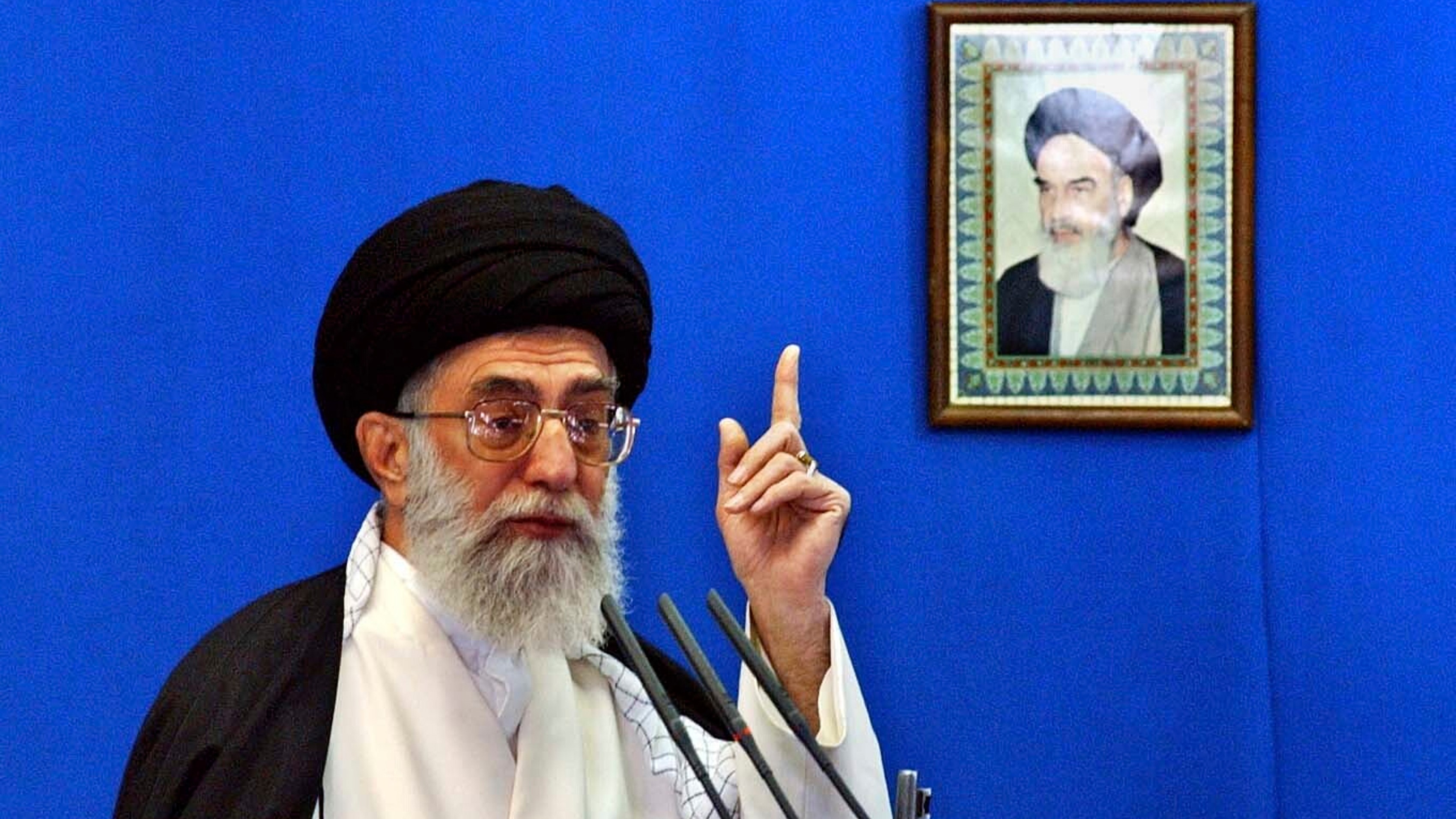 FILE - Iranian Supreme Leader Ayatollah Ali Khamenei, delivers his Friday prayer sermon, in front of a picture of the late revolutionary founder Ayatollah Khomeini. Nov. 5, 2004.
