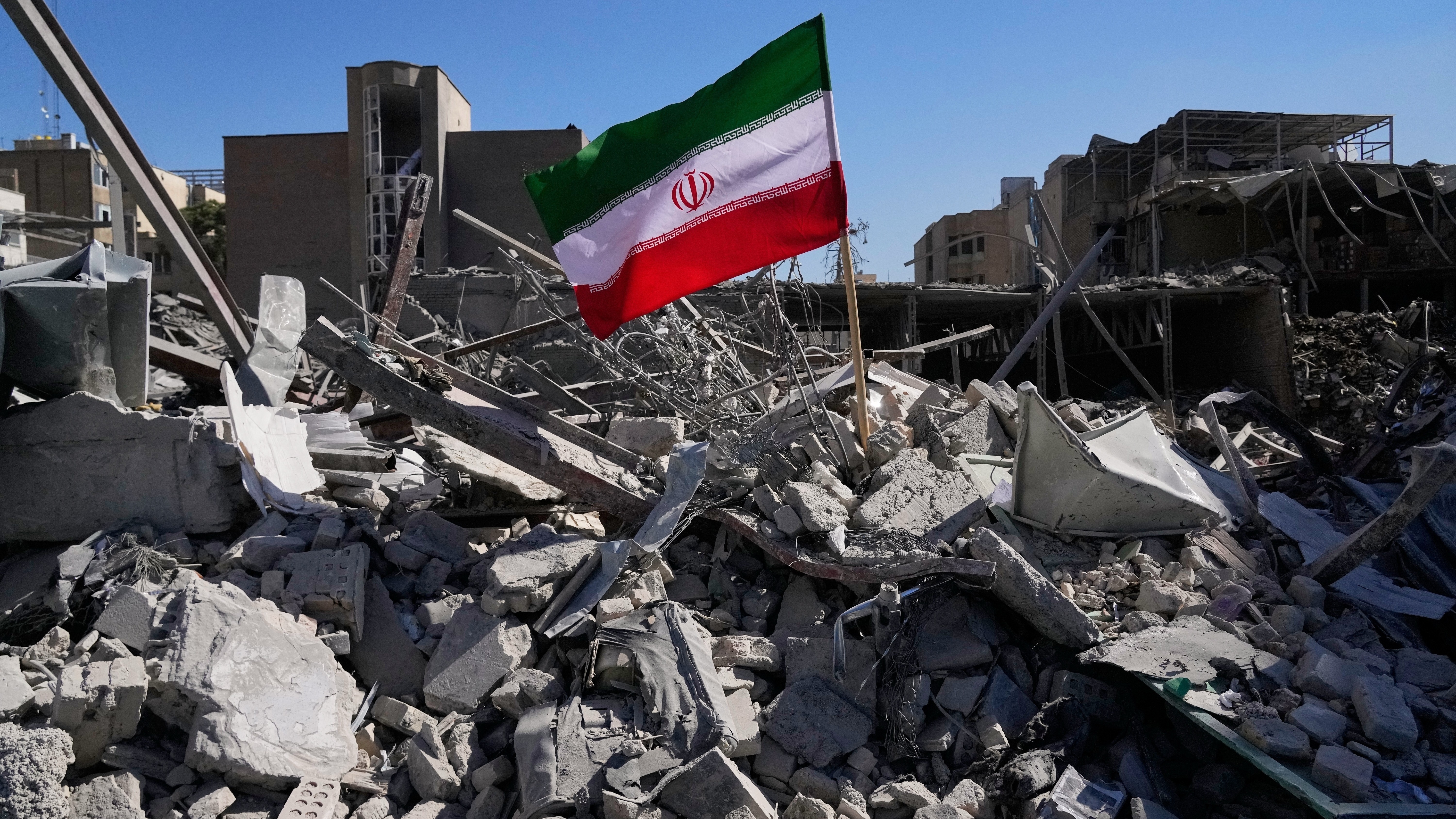 Una bandera iraní, colocada entre las ruinas de una comisaría de policía durante la campaña de ataques de EEUU y Israel en Teherán, el 3 de marzo de 2026. (AP Foto/Vahid Salemi)