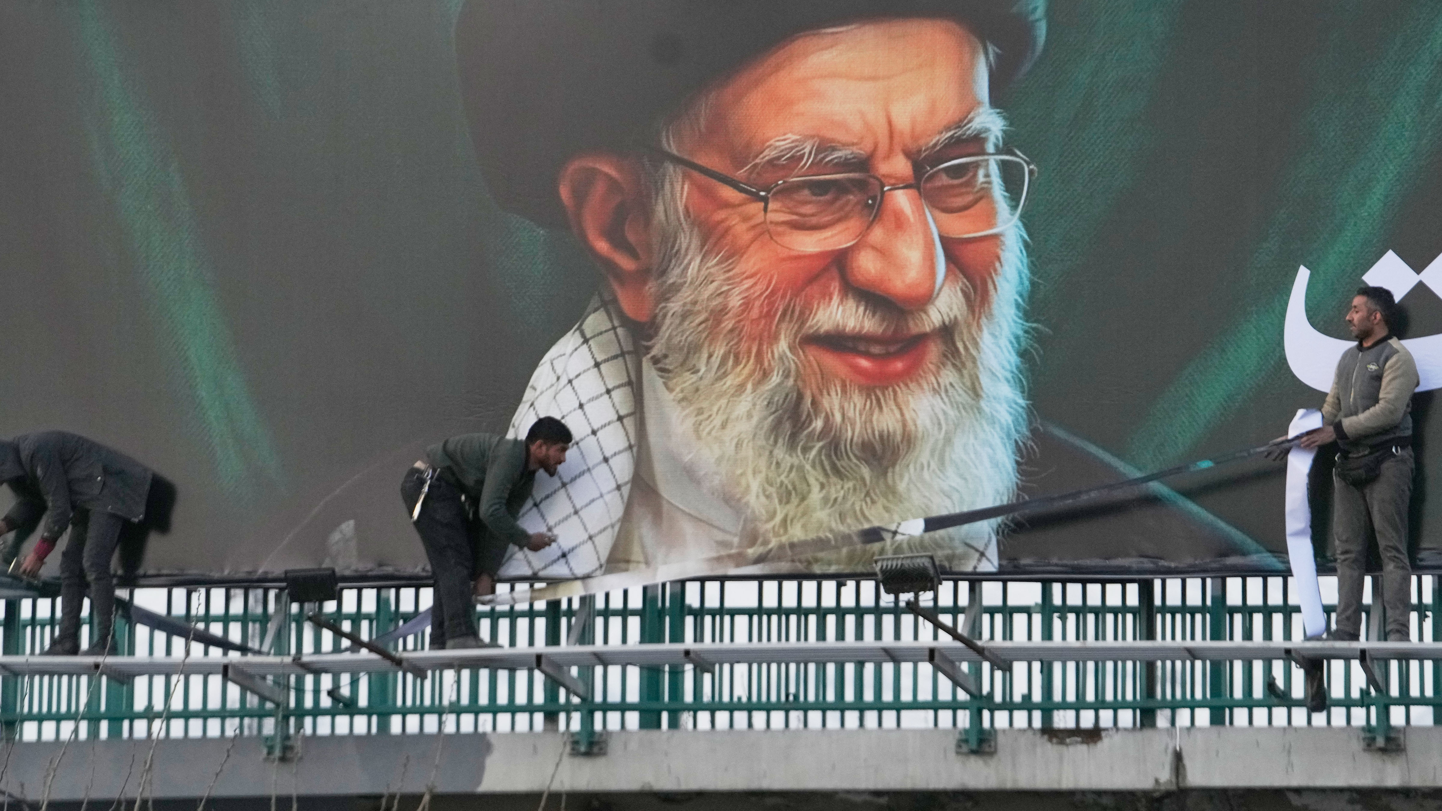 Workers install a billboard on an overpass containing a portrait of the late Iranian Supreme Leader Ayatollah Ali Khamenei, in Tehran, Iran, Monday, March 2, 2026.