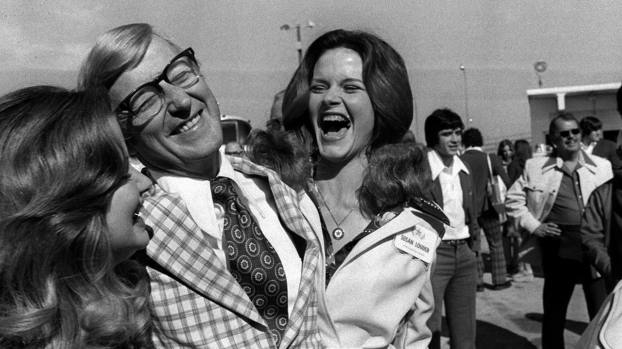 N.C. State head football coach Lou Holtz is surrounded by Astro Bluebonnet Bowl princesses on Dec. 20, 1974, as his Wolfpack arrived to play Houston in the bowl game.