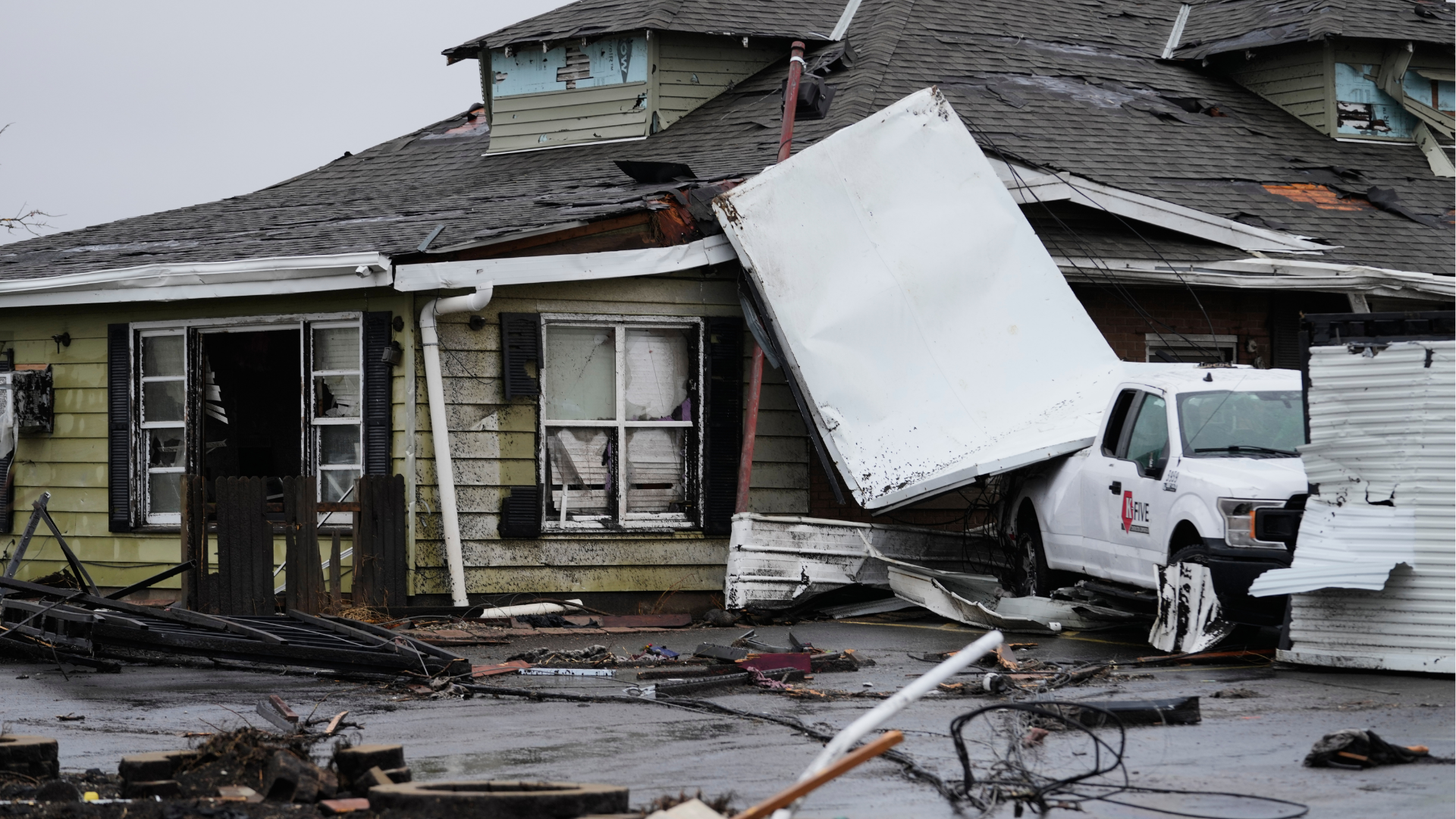 A house and vehicle are damaged in the aftermath of a powerful storm that ripped through the area a day earlier in Kankakee, Ill., Wednesday, March 11, 2026.