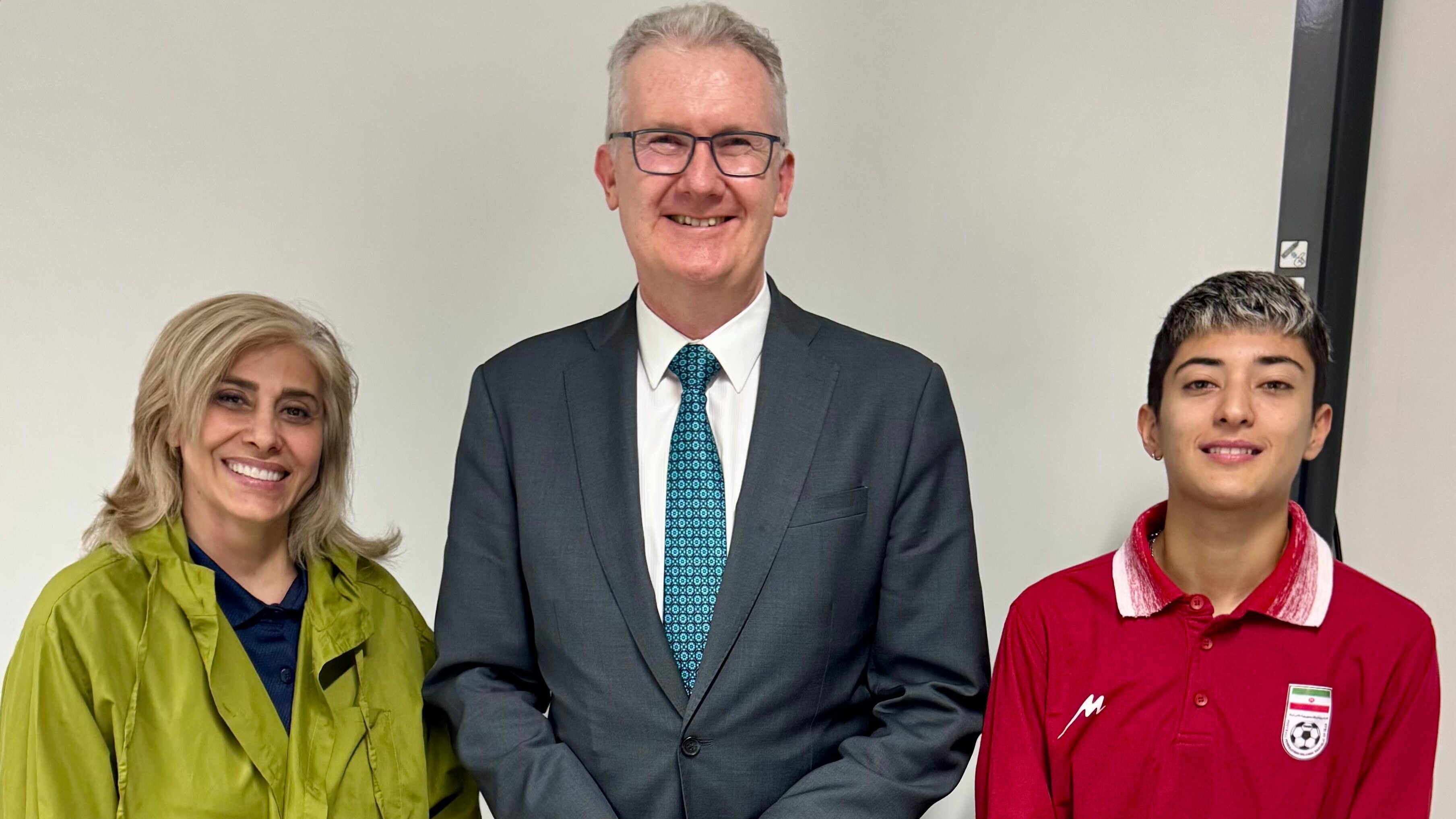 Esta foto Tony Burke posa junto a dos integrantes de la selección iraní de fútbol, quienes recibieron visas humanitarias en Brisbane, el 10 de marzo de 2026.