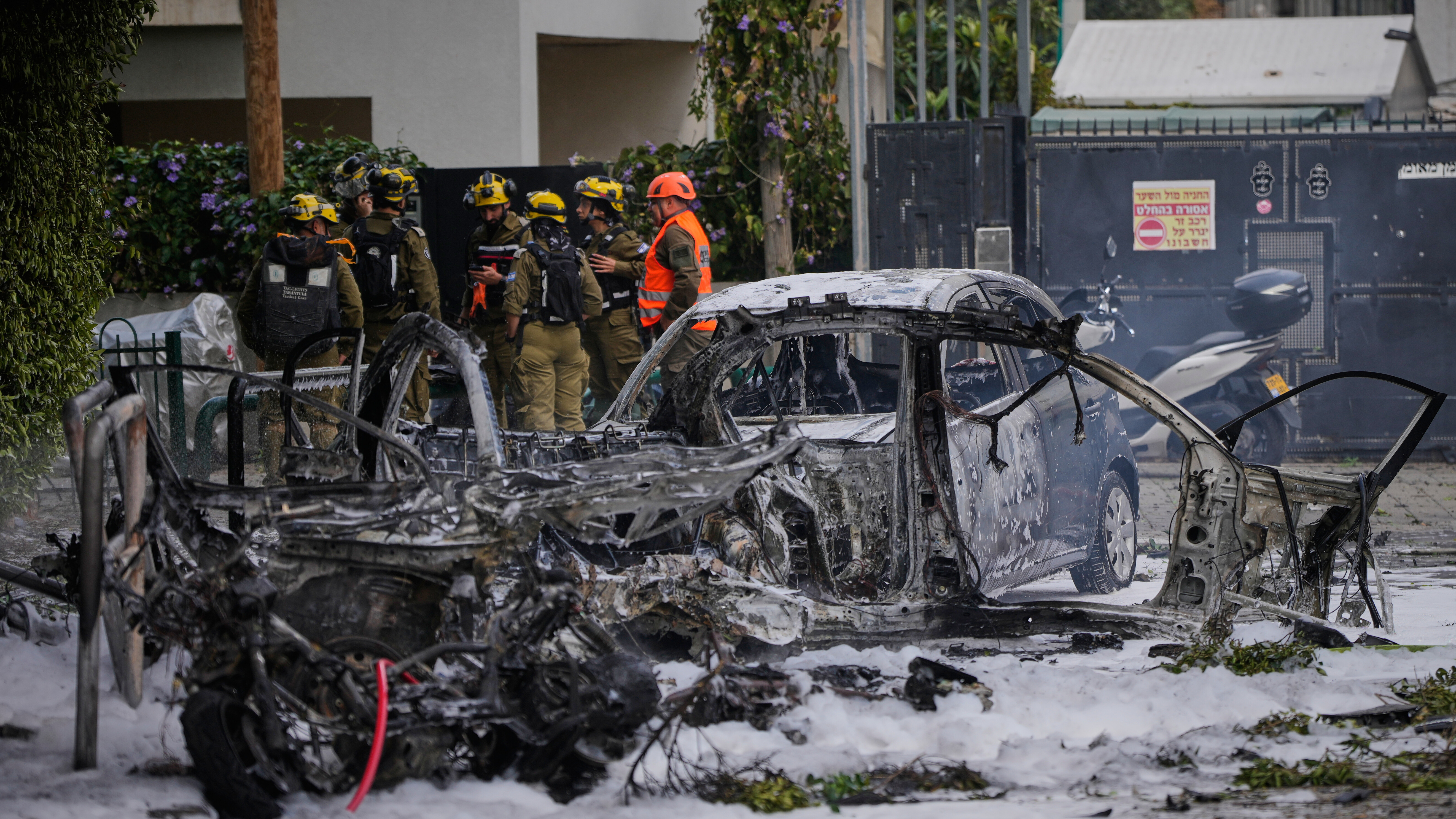 Israeli security forces inspect a site damaged during an Iranian missile strike in Tel Aviv, Israel, Sunday, March 15, 2026.